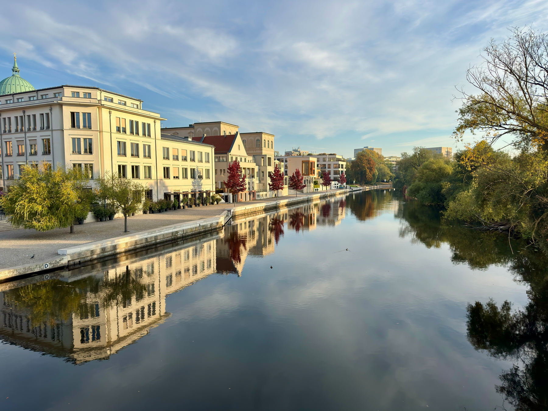 Die Havel spiegelt die Gebäude und Bäume an seinem Ufer bei klarem Himmel wider.
