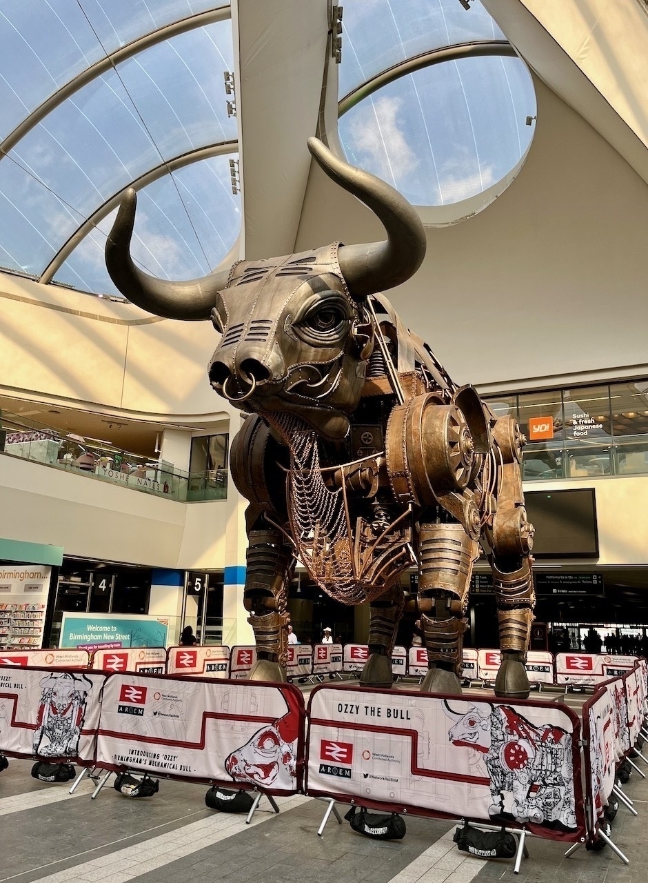 An huge mechanical bull, made of industrial metal parts stands in the atrium of Birmingham's New Street station, surrounded by barriers to stop people trying to climb on him.