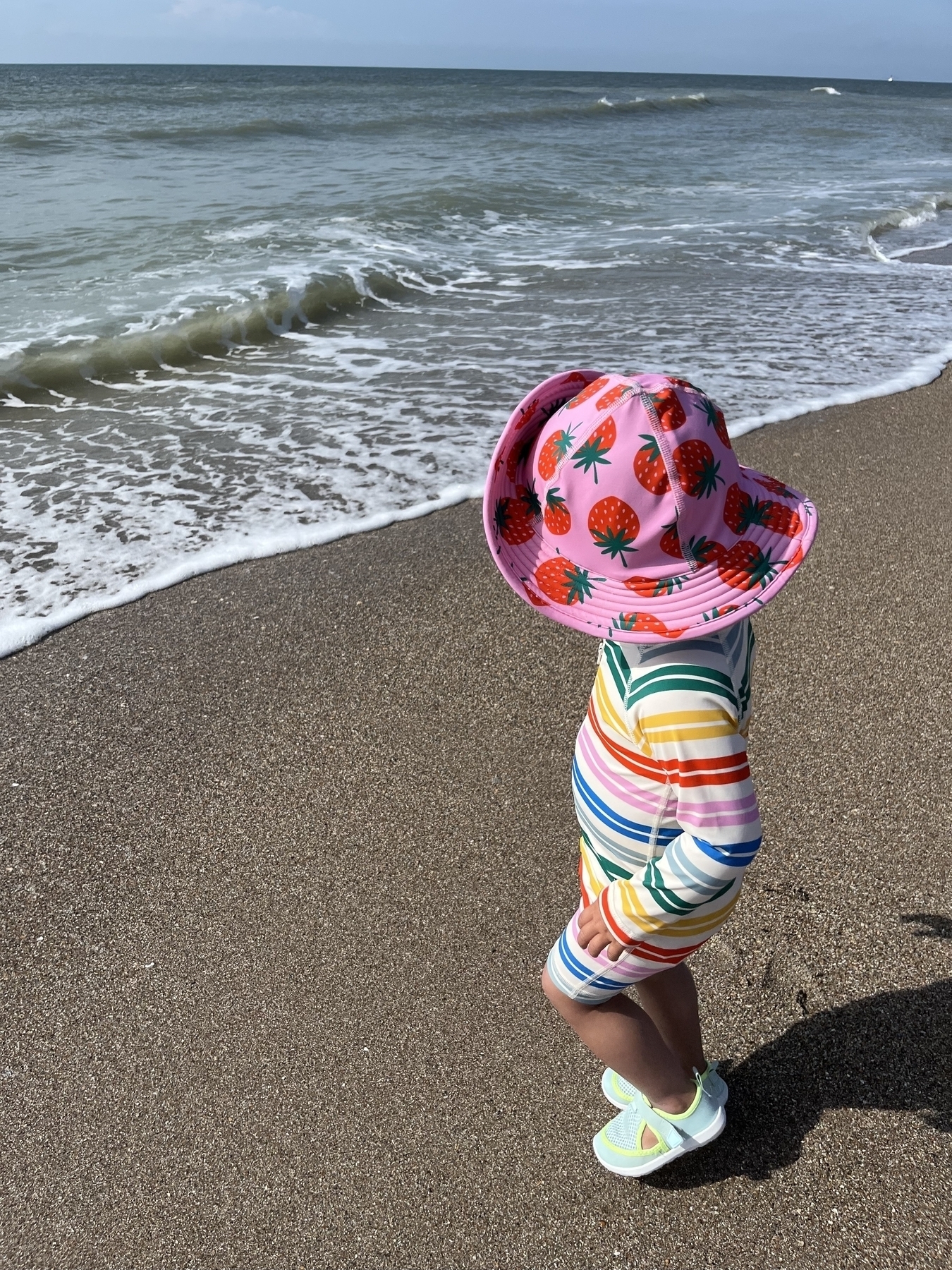 My daughter in her bathing suit staring at the ocean
