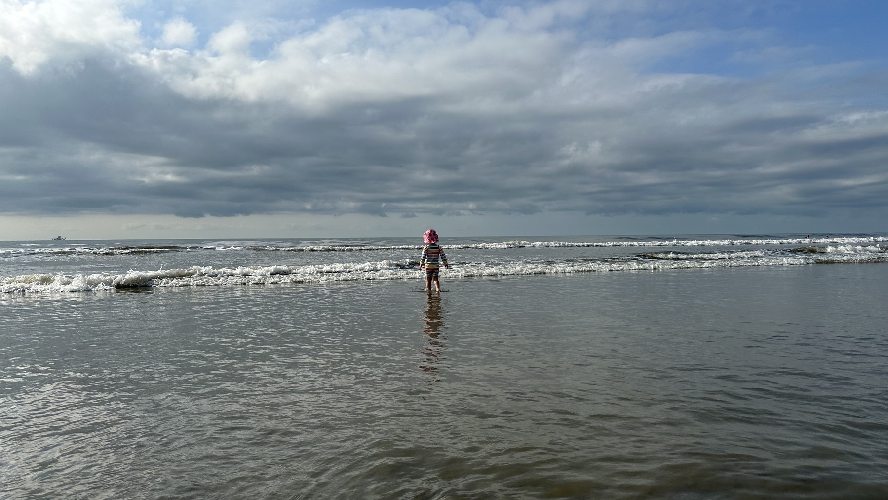 My daughter standing in the waves on the beach