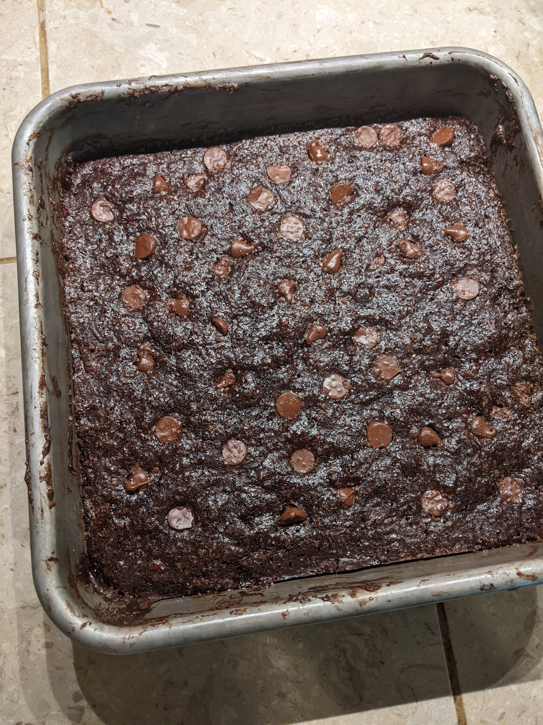 pan of brownies with sugar granules on the surface, studded with chocolate chips 