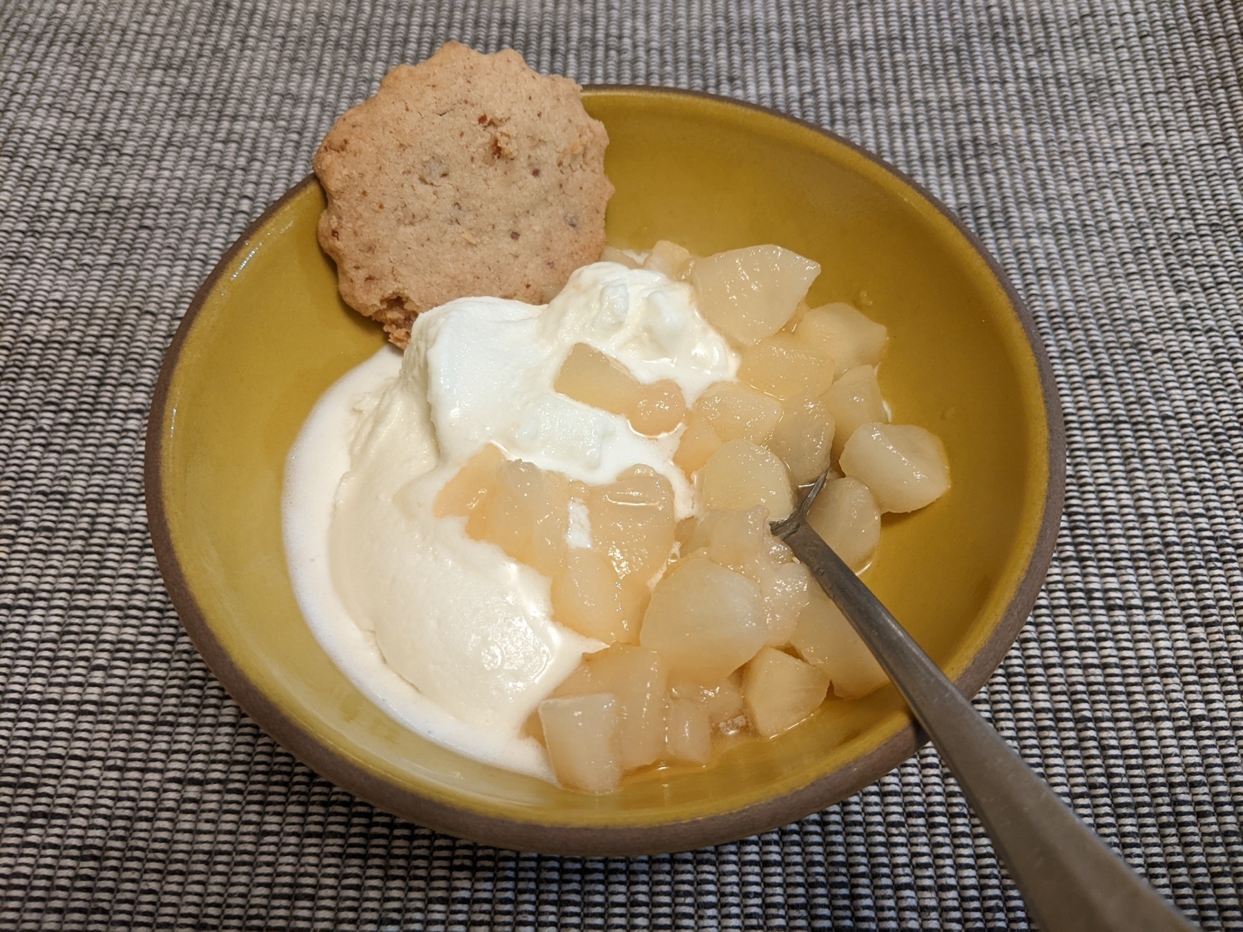 Diced cooked peaches with vanilla ice cream and a pecan cookie