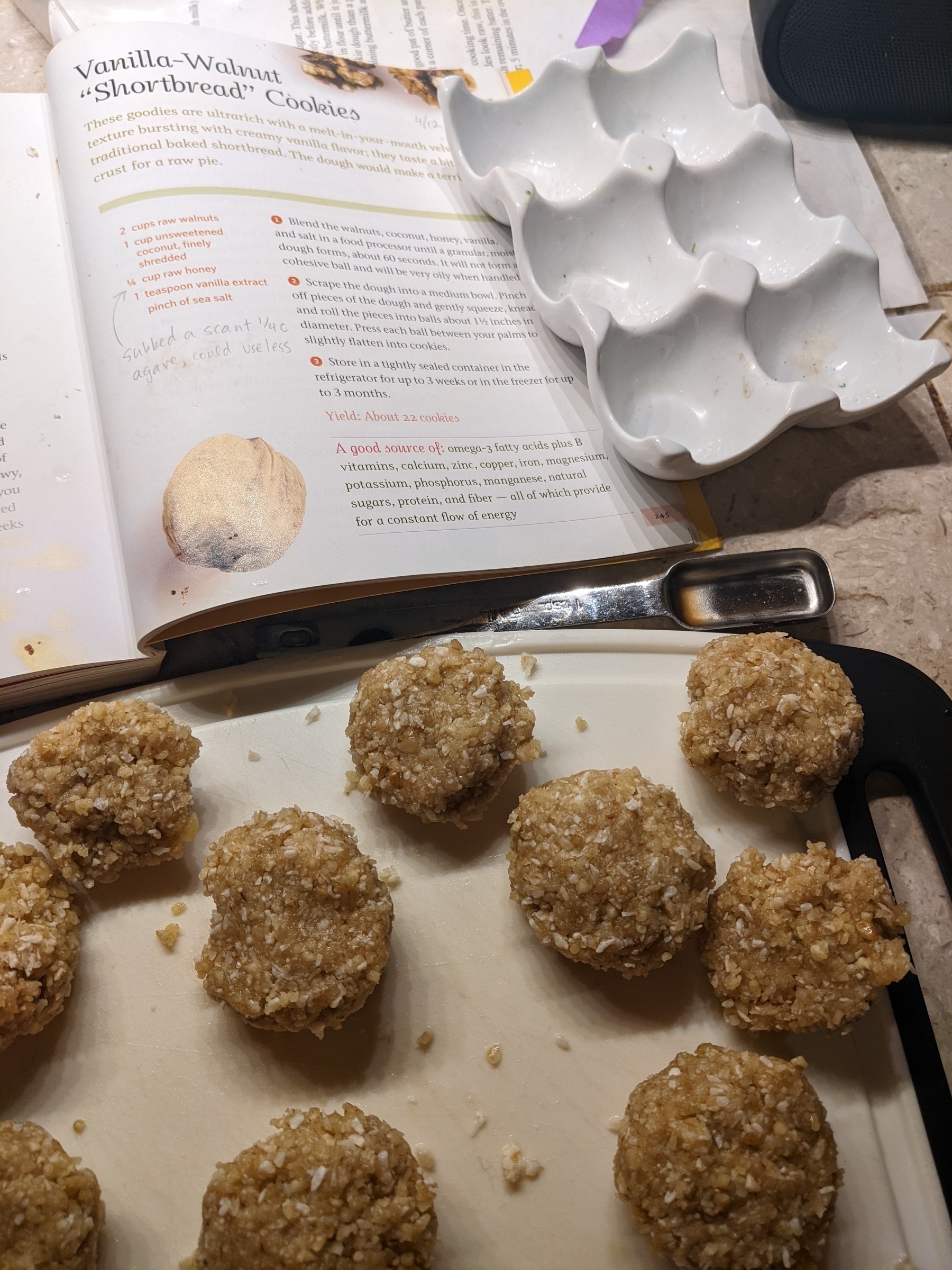 ground nut and coconut balls lined up on a cutting board beside the recipe 