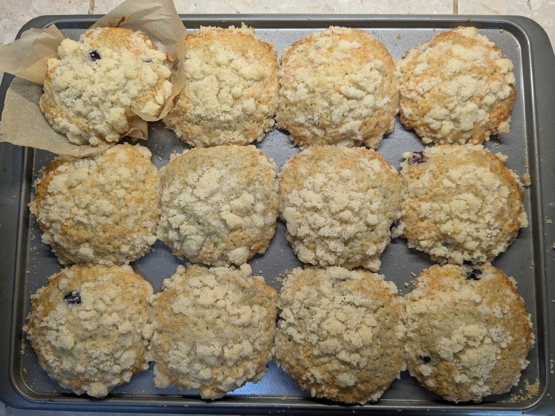 tray of twelve muffins baked with crispy edges and chunky crumb topping 