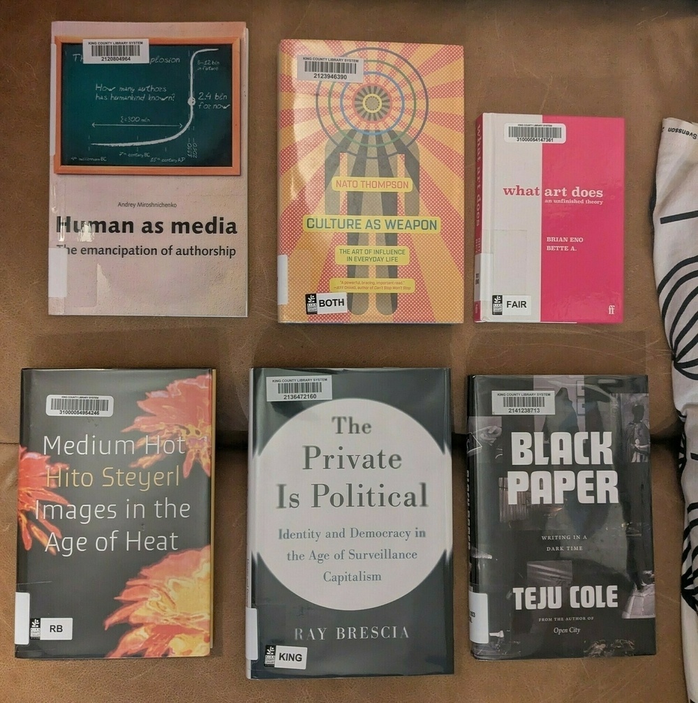 flatlay of six nonfiction books, three with mostly black covers, three with lots of orange