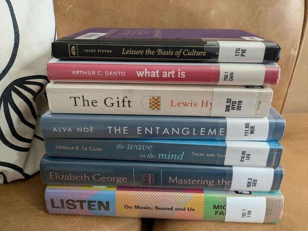 stack of 7 library books, two on writing process, the rest on art and culture and making