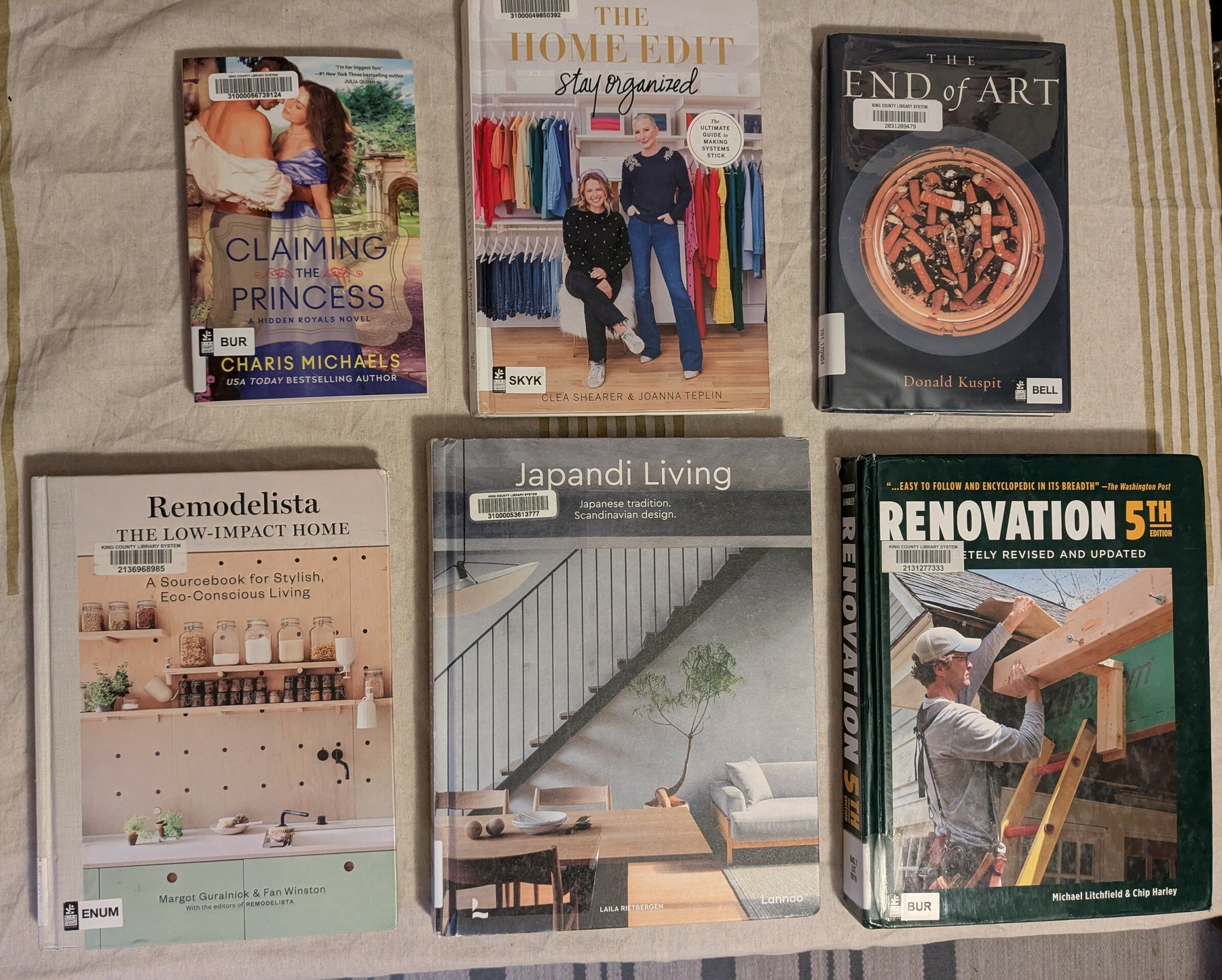 flatlay of six library books: one novel, one nonfiction, and four oversize home inspo books 