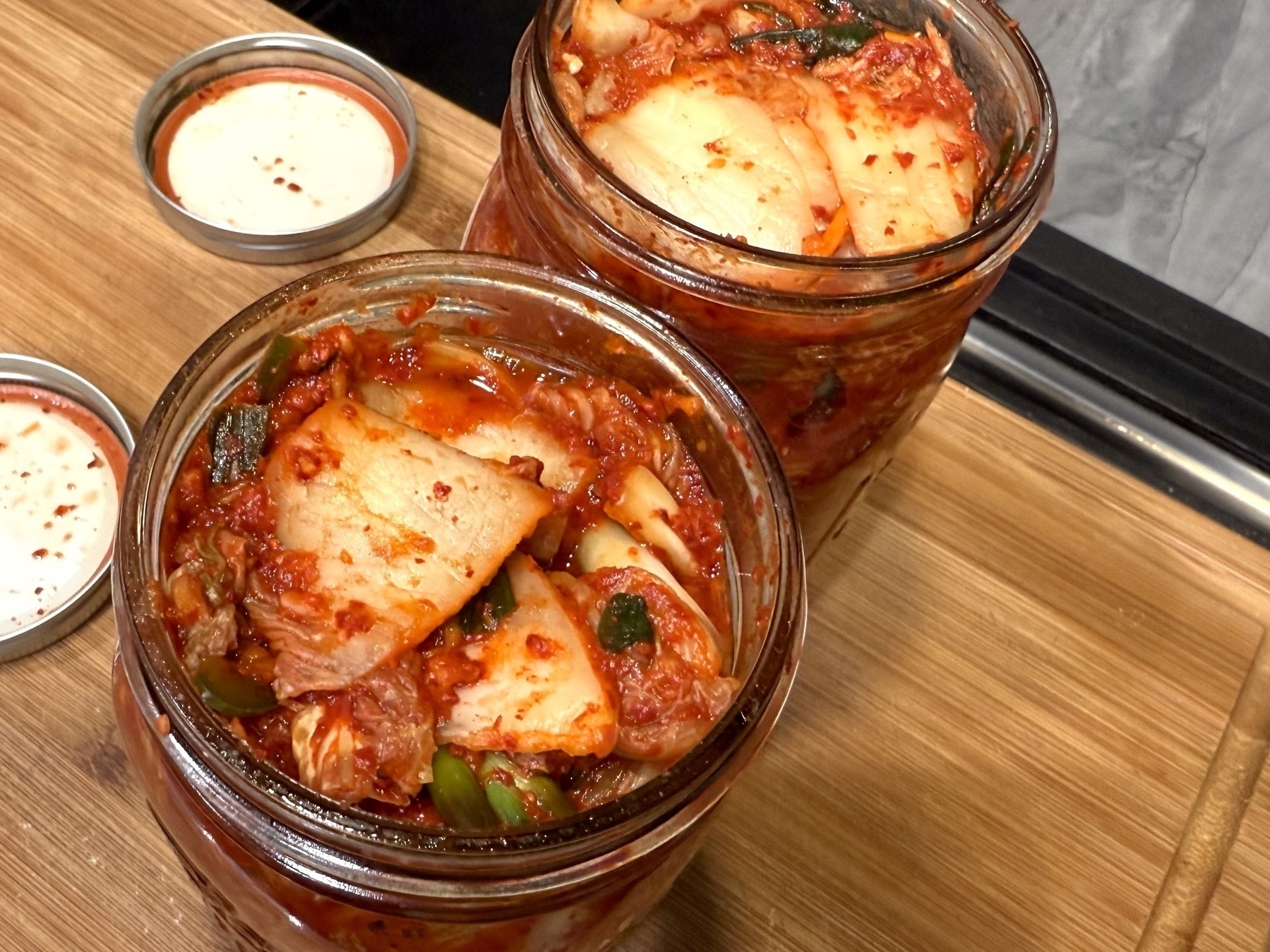 Two open mason jars of 3 day old kimchi. 