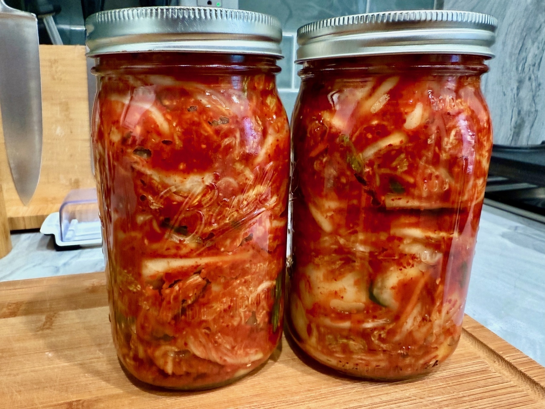 two 1 quart mason jars filled with fresh kimchi. 