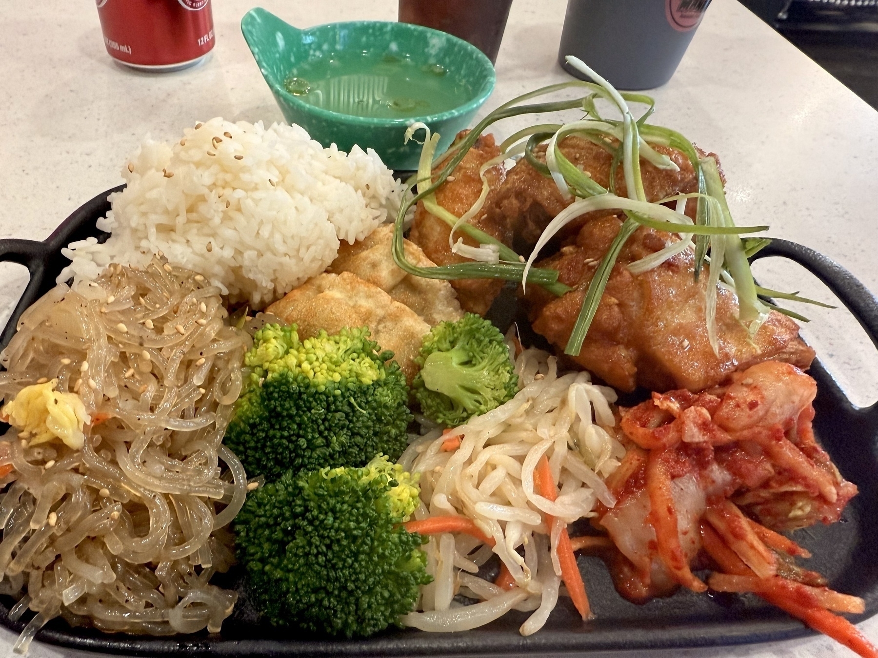 A plate of Korean fried chicken and various vegetable sides. 