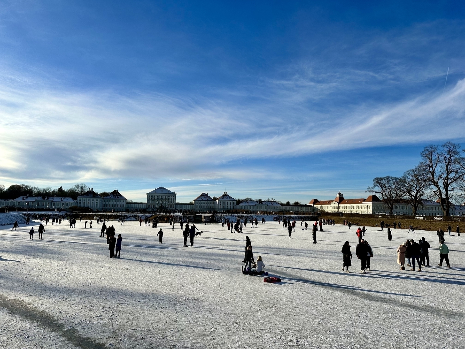 Nymphenburg Palace Parking (Munich) in the winter. People enjoy a frozen over canal.