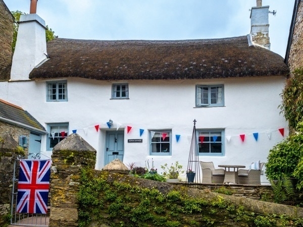 a photo of a cottage with union jack flags and bunting