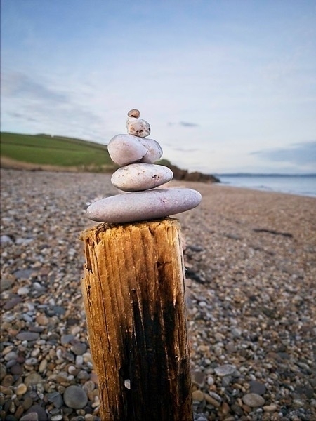 Photo of a pile of pebbles on a stake on the beach