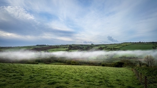 a landscape photo of mist in a valley