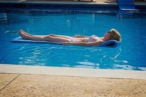 a photo of a woman drifting in a pool on a float
