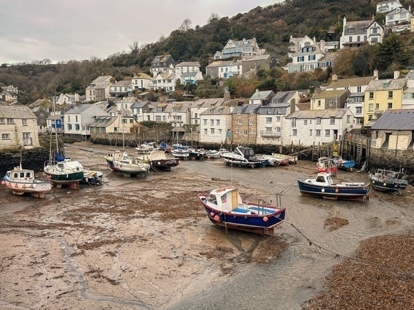 A photo of fishing boats sitting on the sand as the tide is out