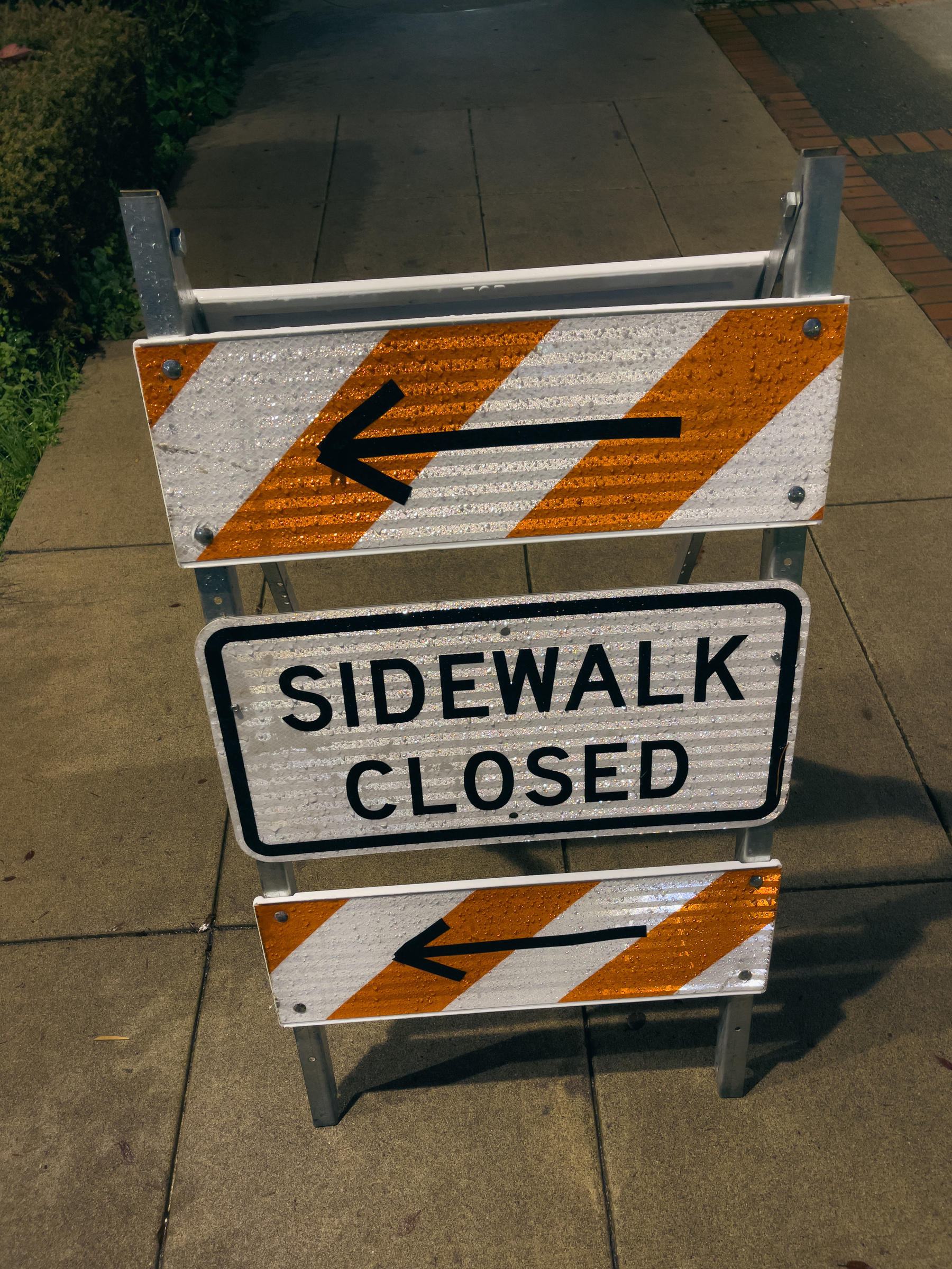 Sidewalk closed sandwich sign with directional arrow pointing to the left.