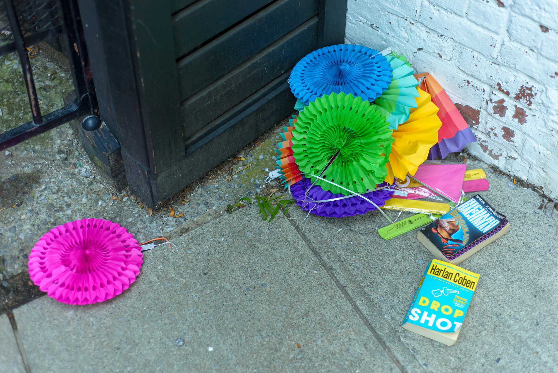 Colorful pinwheel decorations and books lying on the ground for people to take.