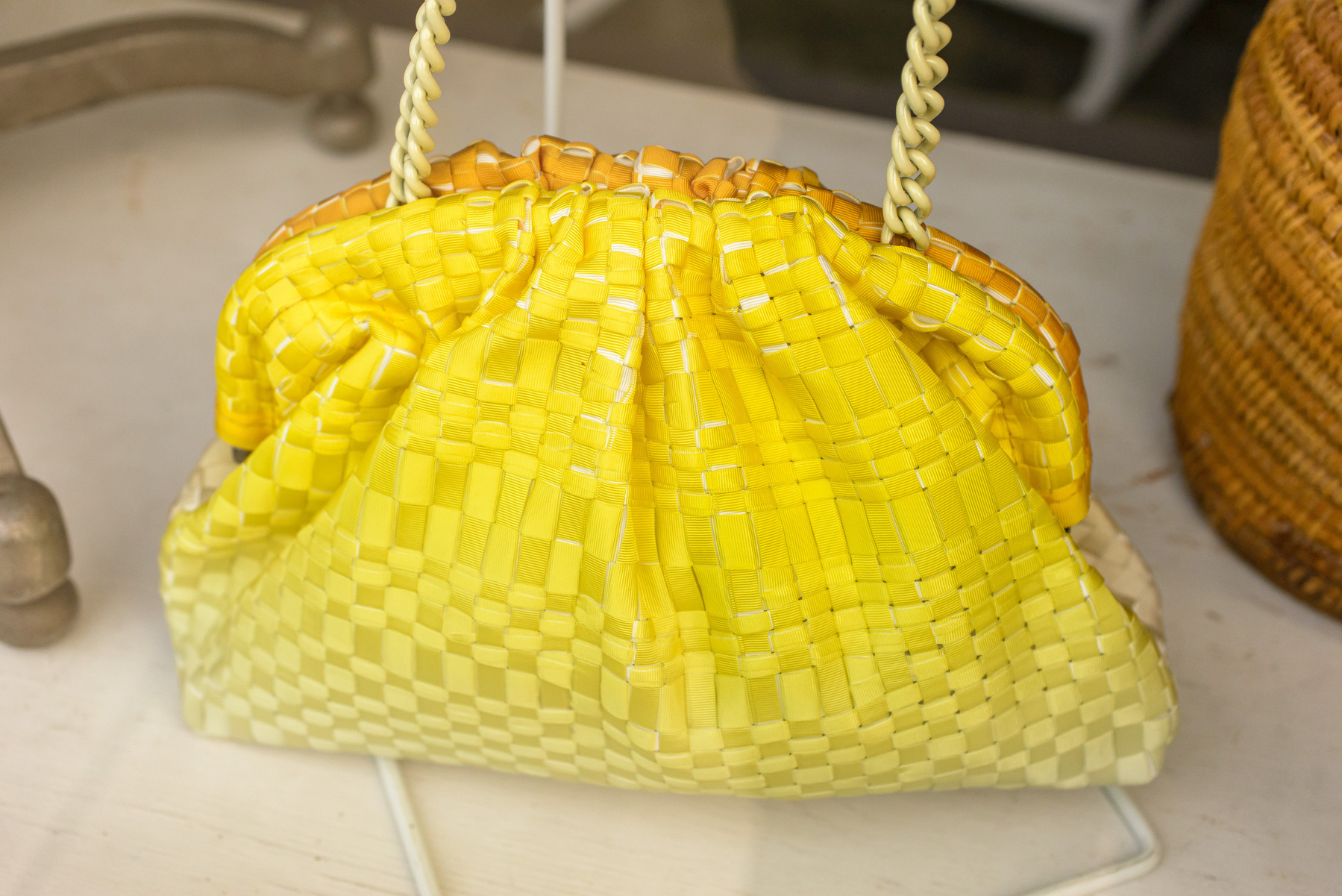 Yellow woven purse in a shop window.