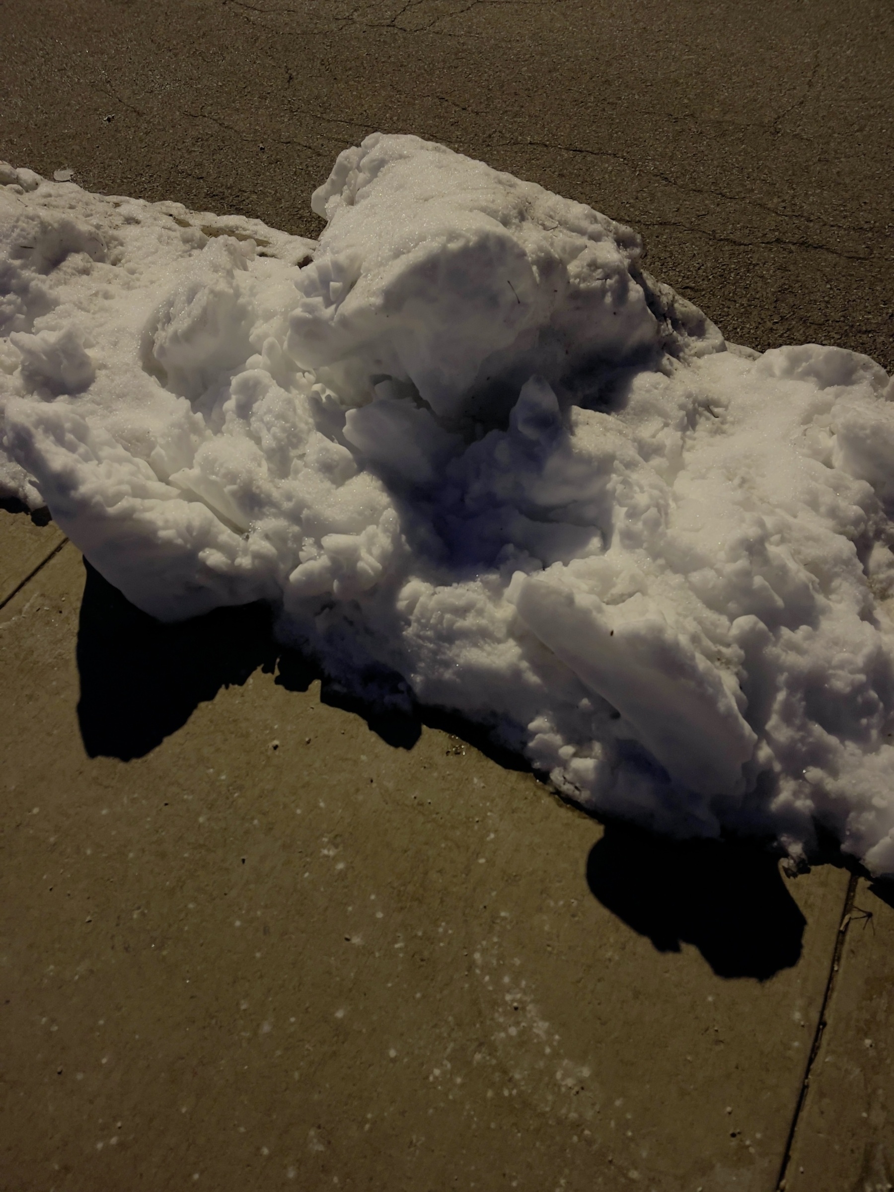Snow between sidewalk and street.