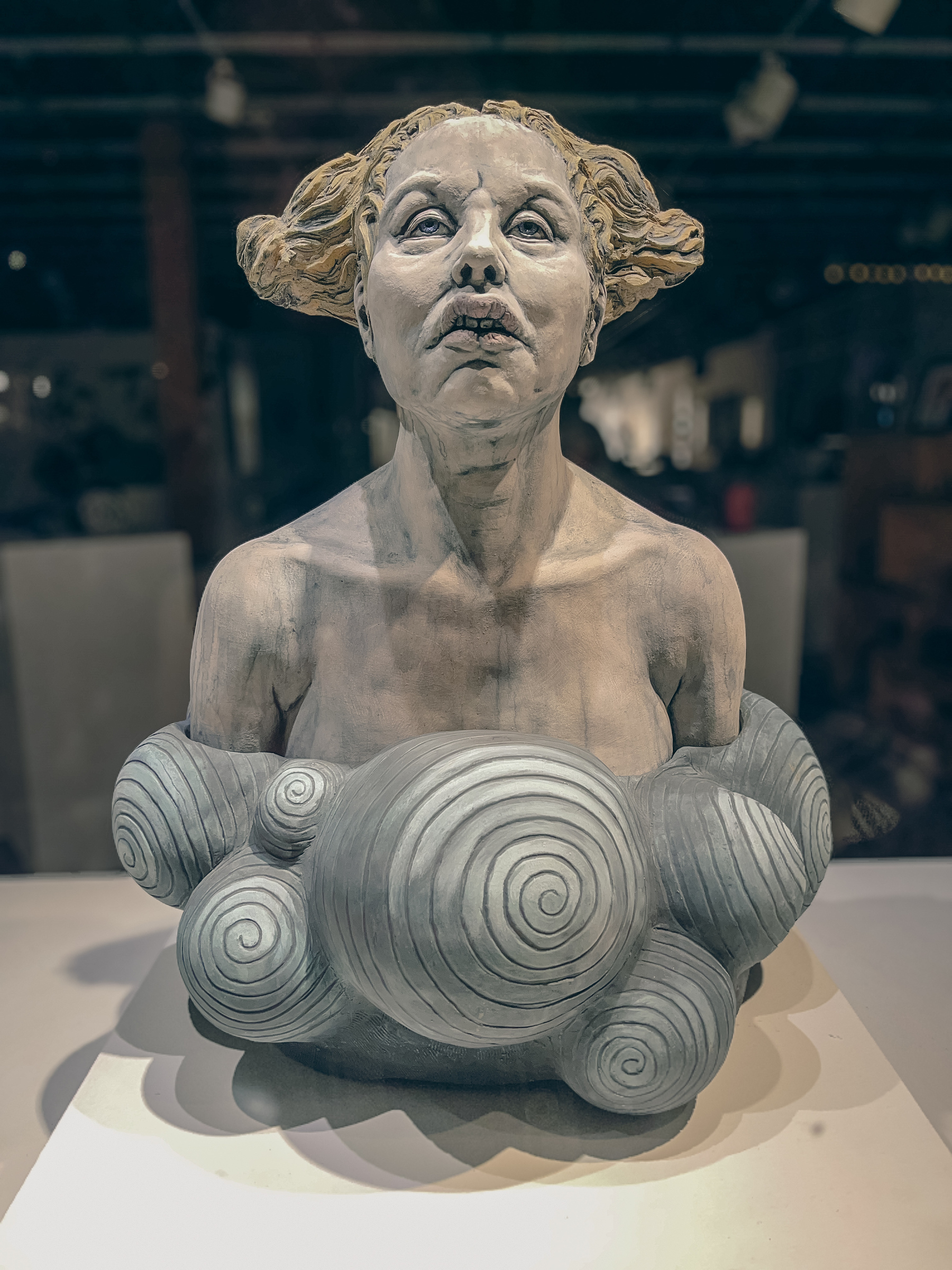 Funny clay sculpture of a woman in an art gallery window.
