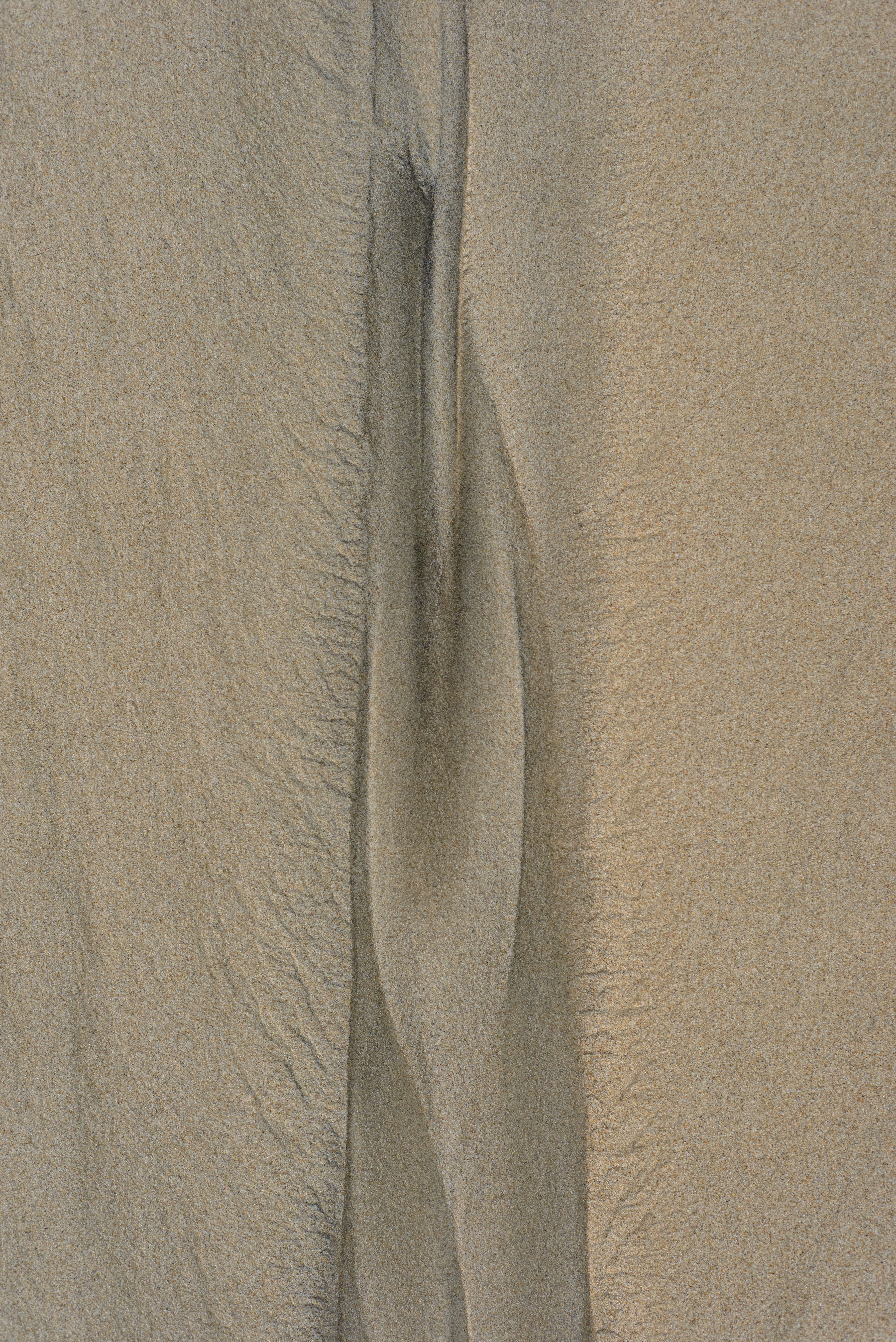 Erosion pattern in sand looking a little like a woman’s vulva.