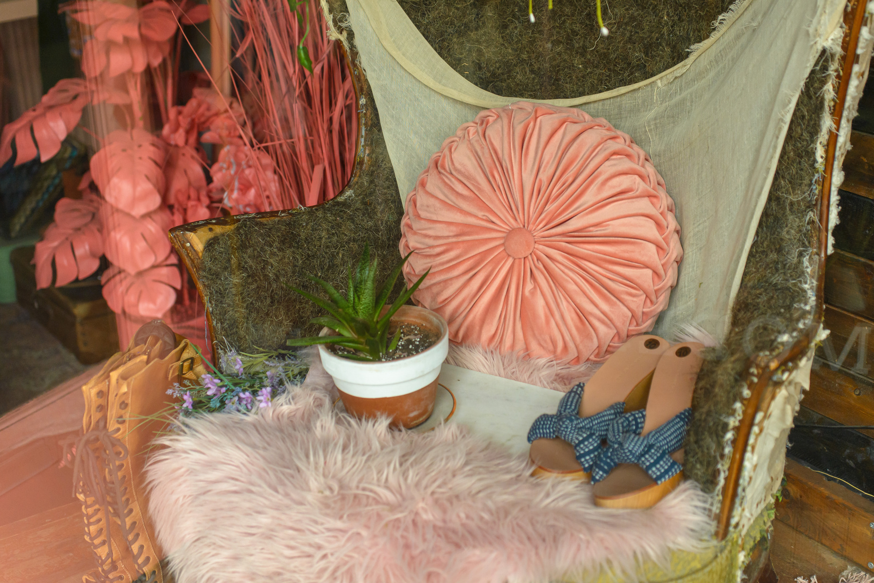 pink pleated curtain in an old chair frame partially covered in stuffing and fabric