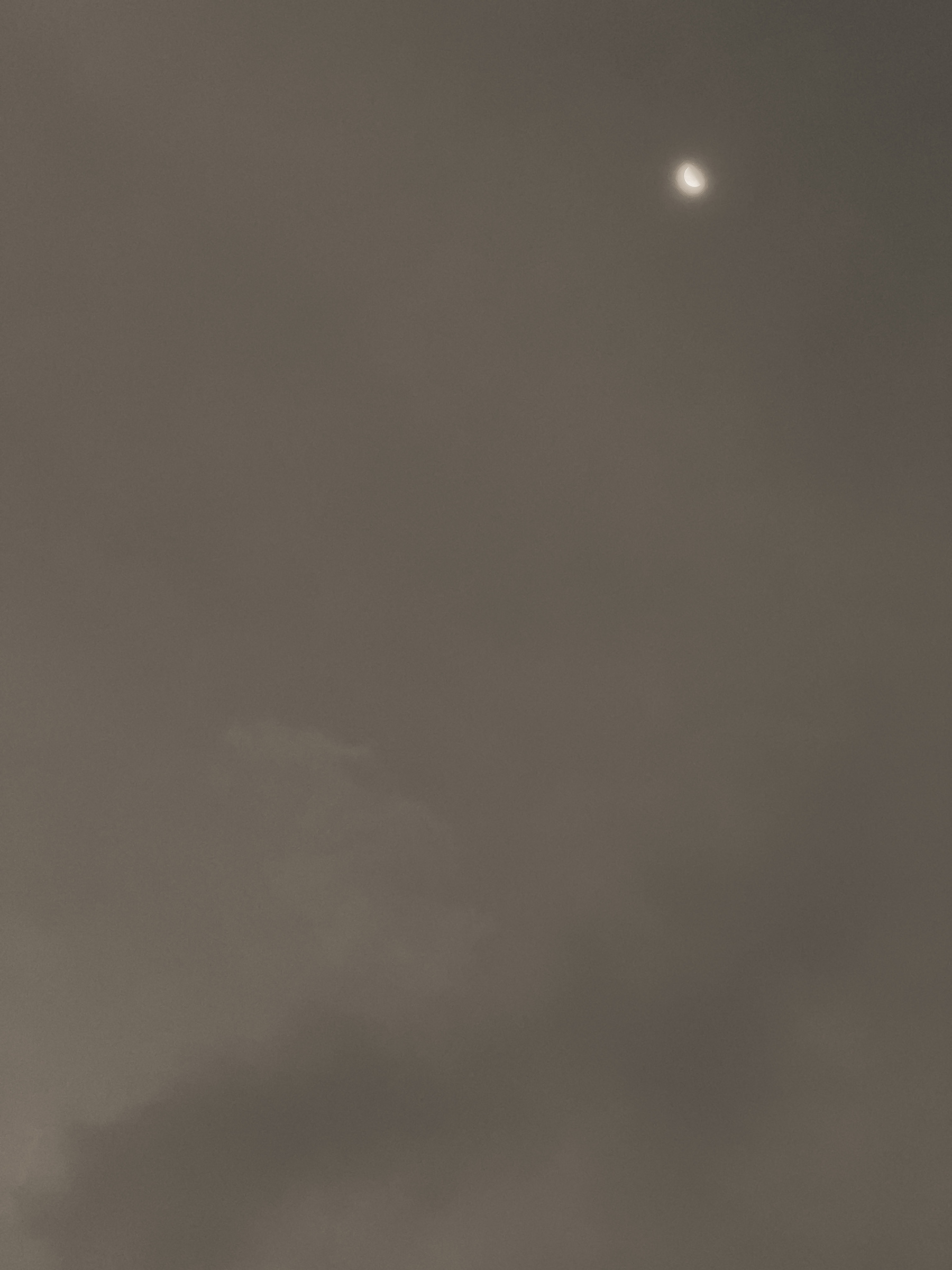 Slipper moon in a hazy sky.
