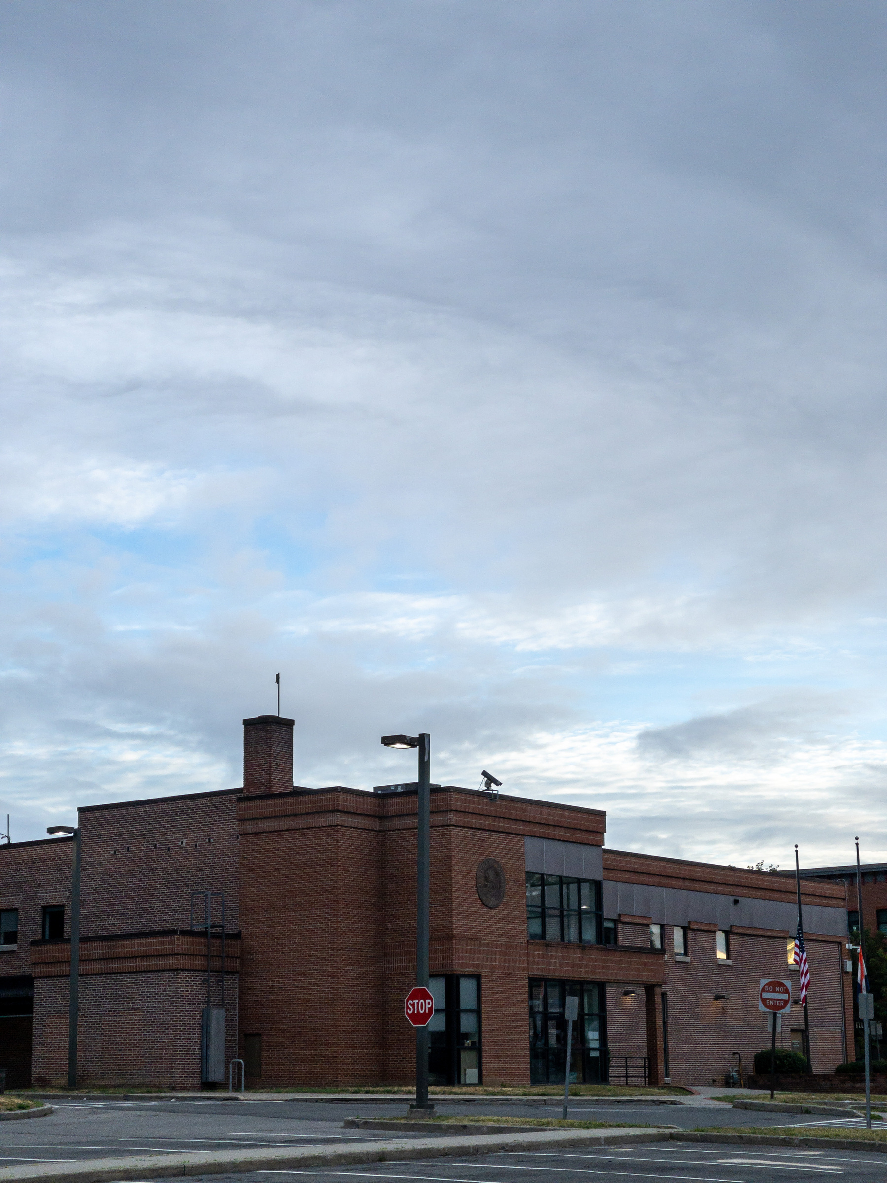 Morning partly cloudy sky over brick building.