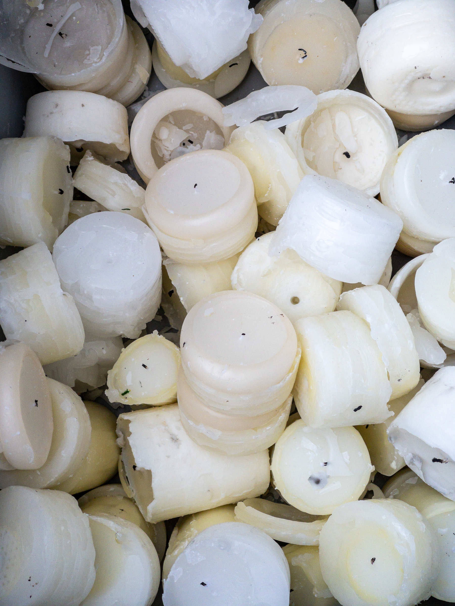 Pile of partially used white candles.