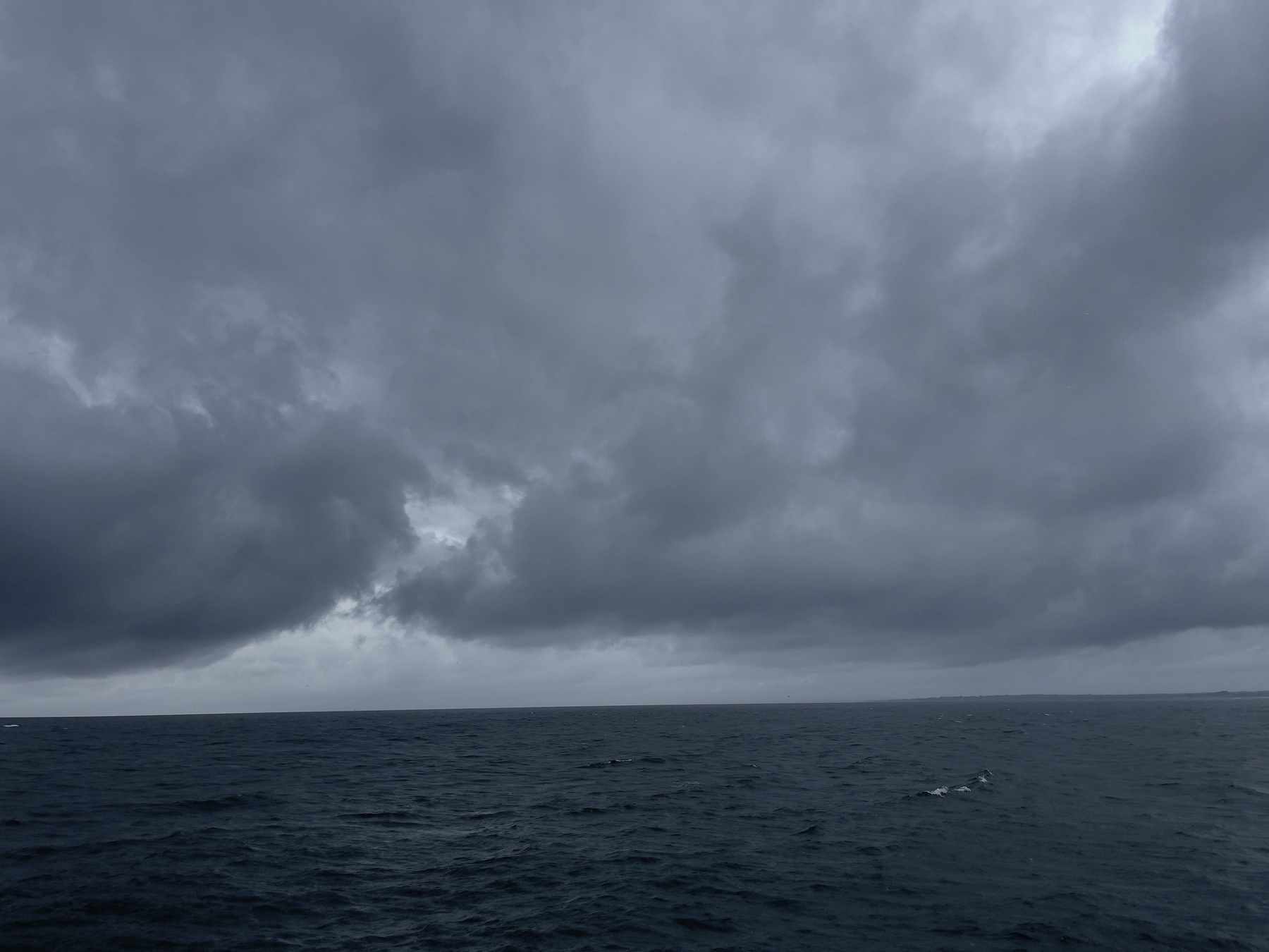 Ocean and storm clouds, horizon line tilted down to the left.