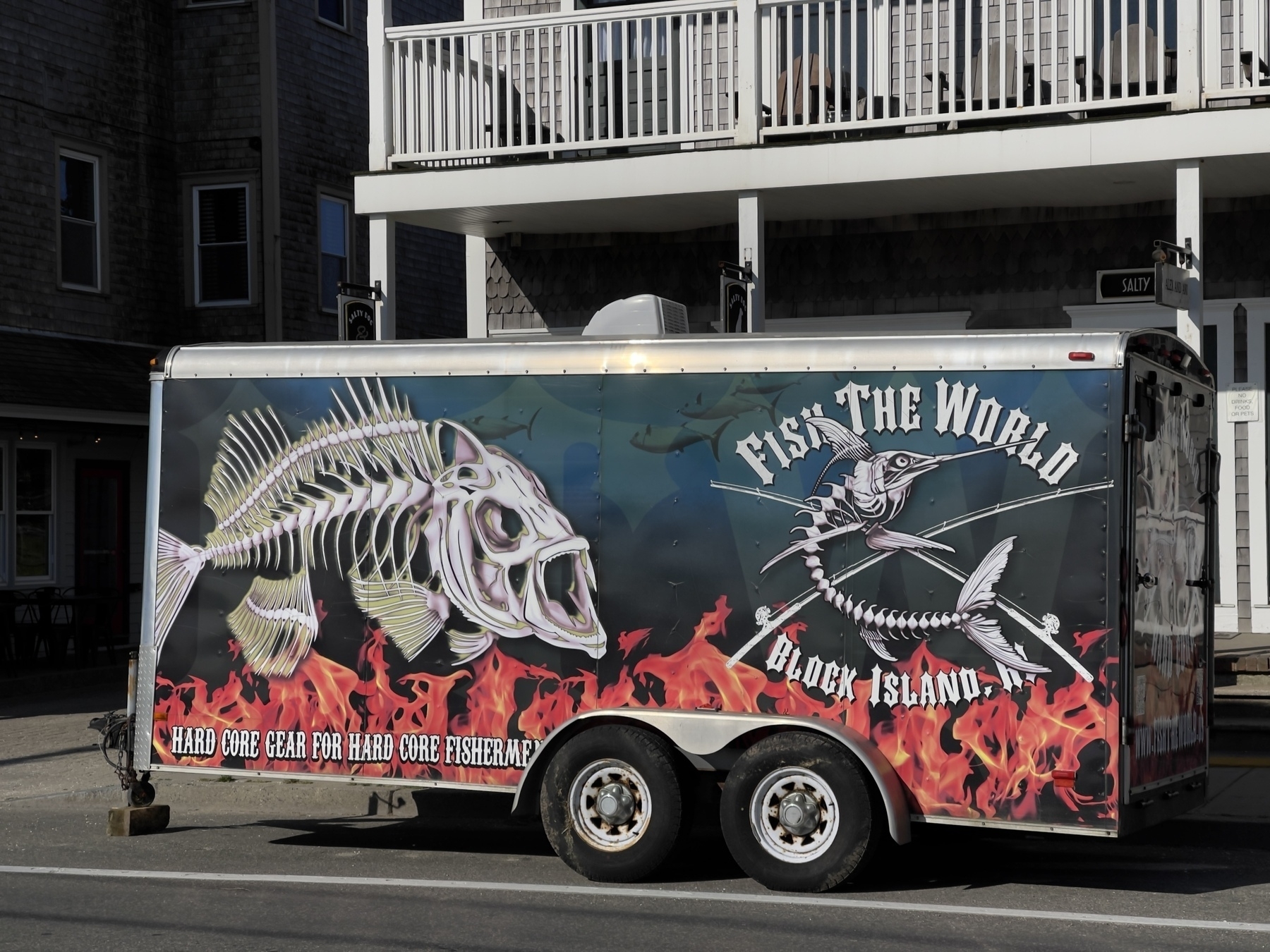 Fish The World trailer parked on street.