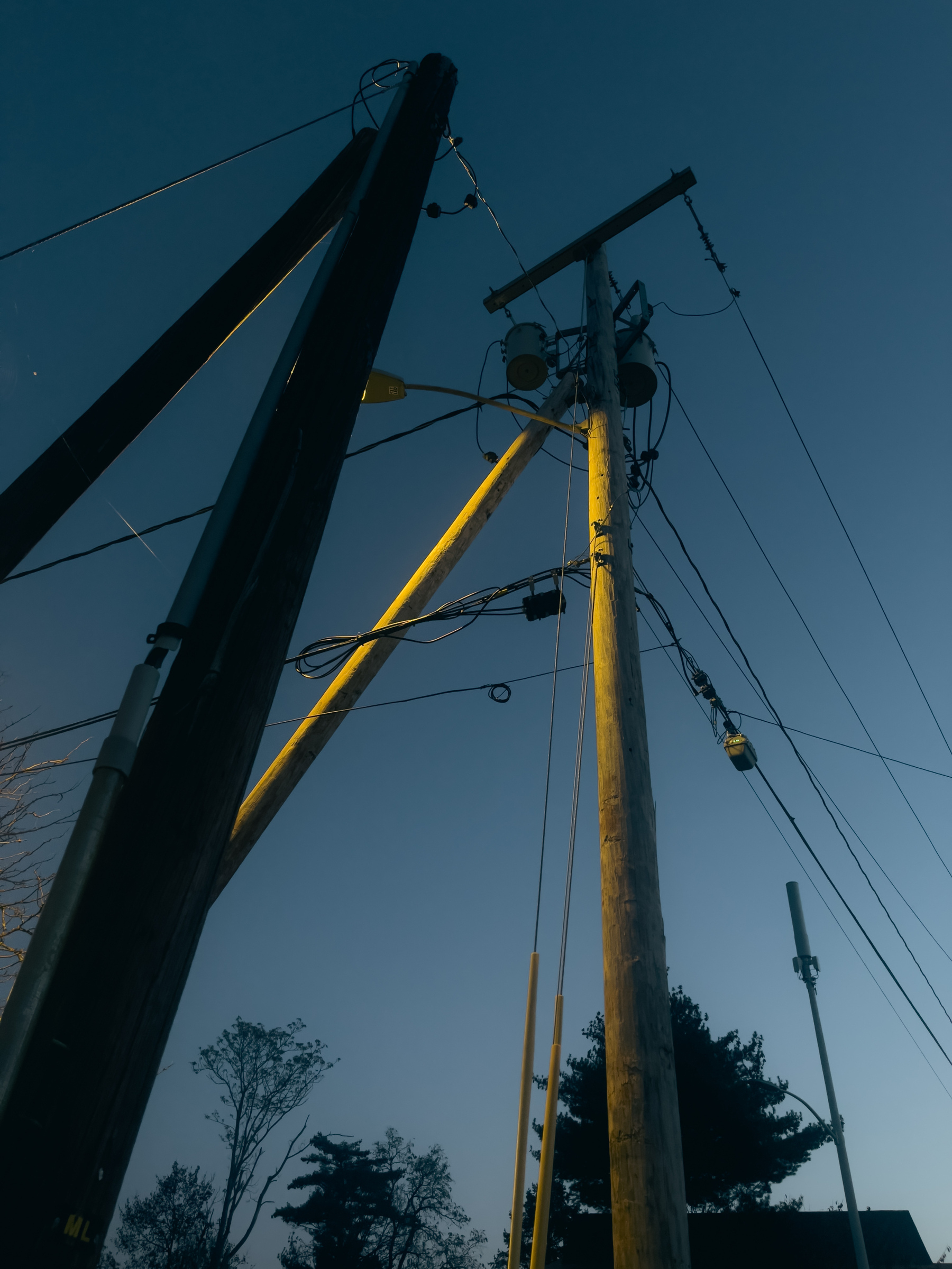 Utility poles and wires against a dawn sky.