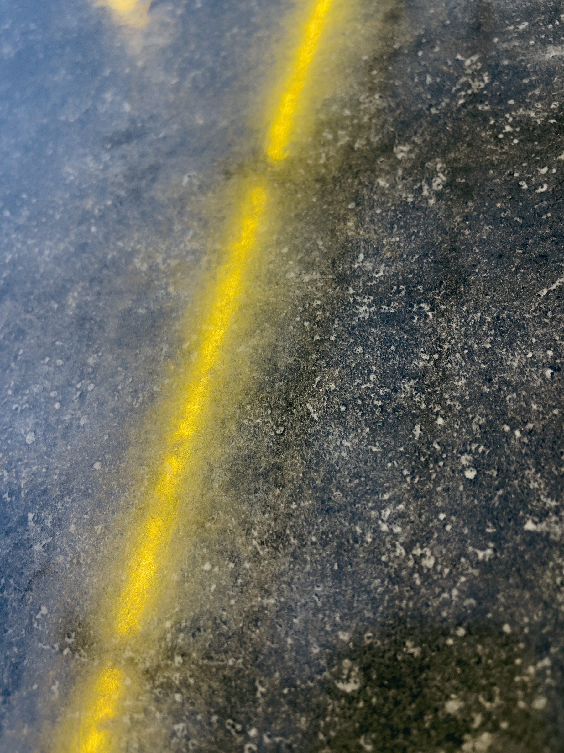 Yellow strip lights reflected by a polished granite table surface.