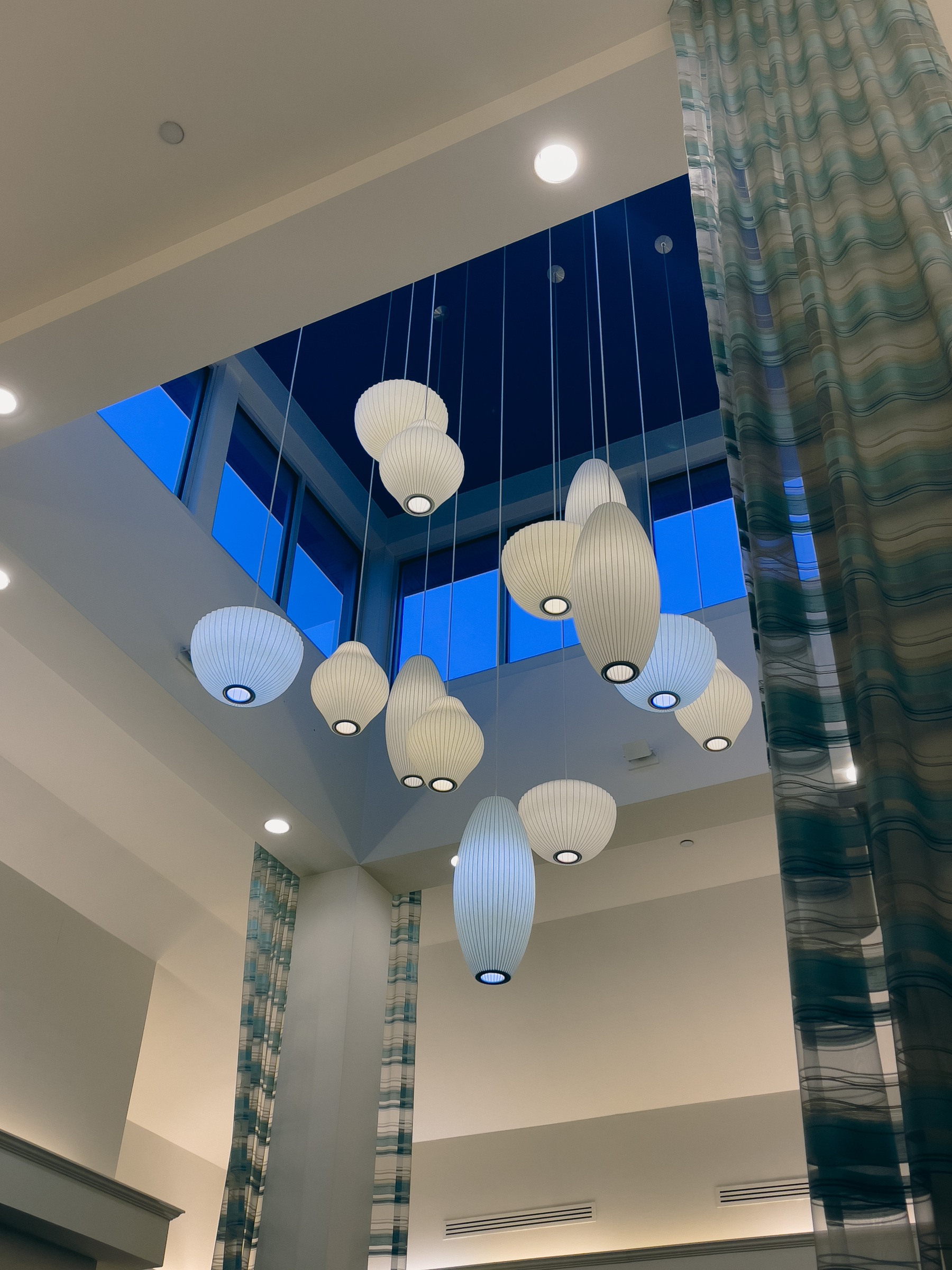 Pendant light fixtures in a soaring hotel lobby.
