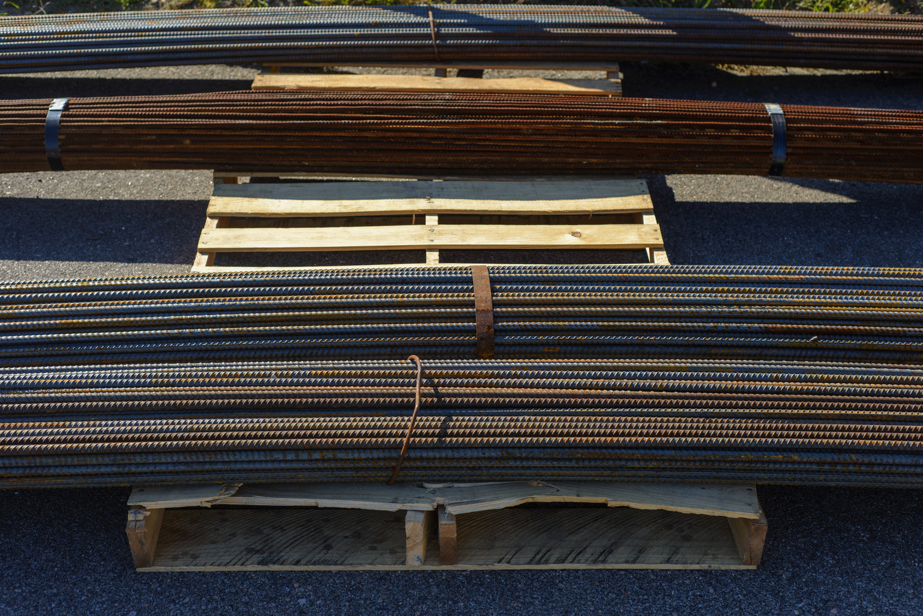 Reinforcing bars on a wooden pallet. Bars running horizontally across the frame.
