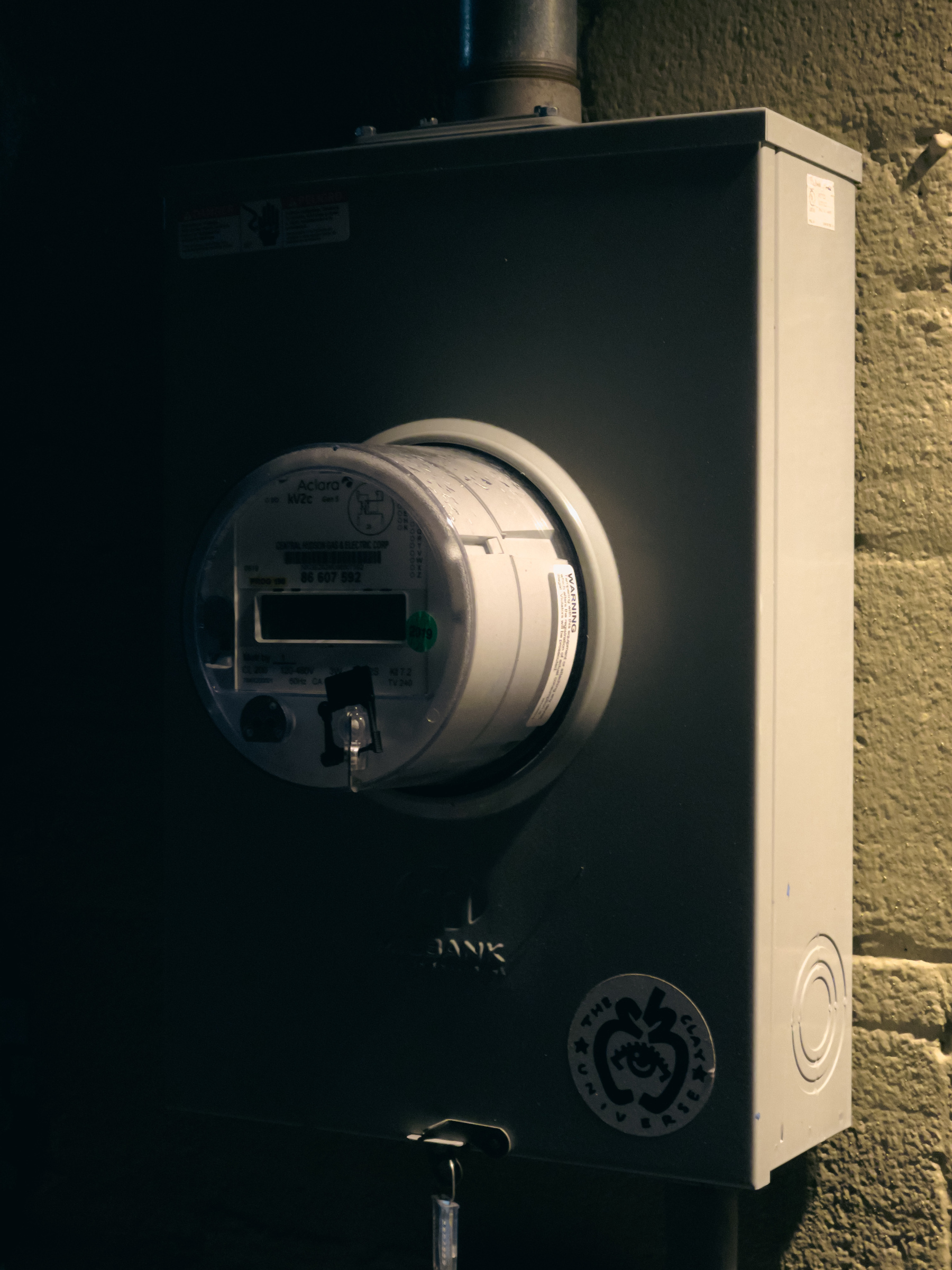 Closeup of electric meter lit by building lights.