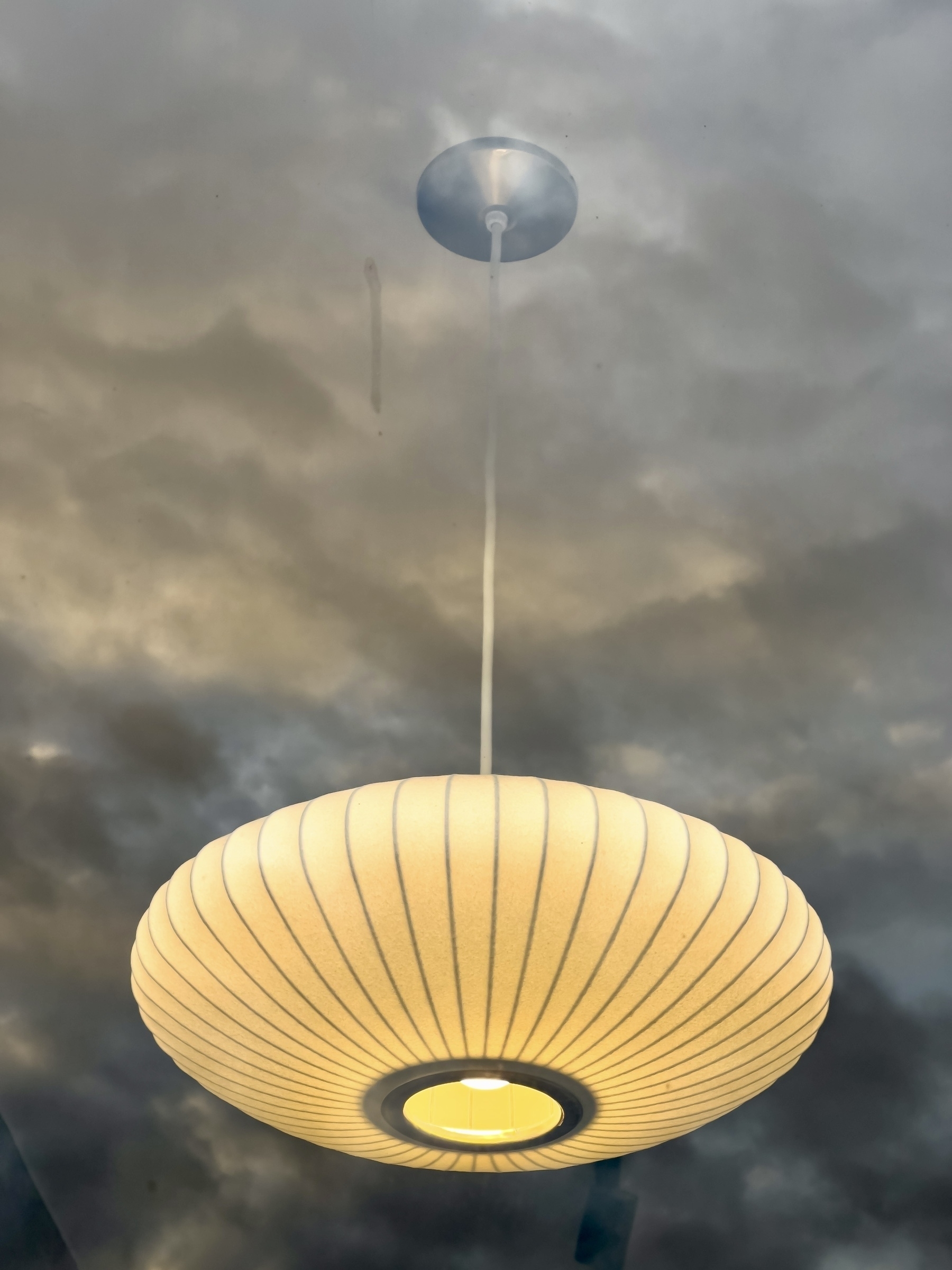 lamp hanging from sky effect, lamp in shop window overlaid with clouds in the sky reflection