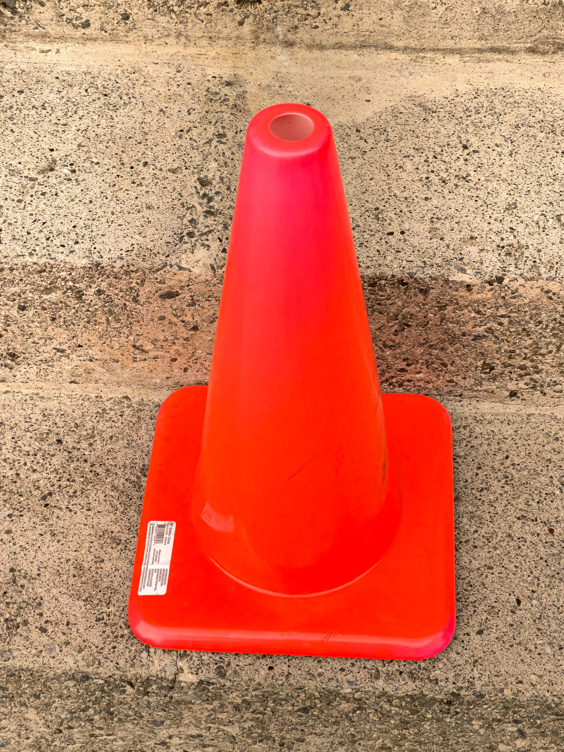 Orange/Red traffic cone on concrete steps.