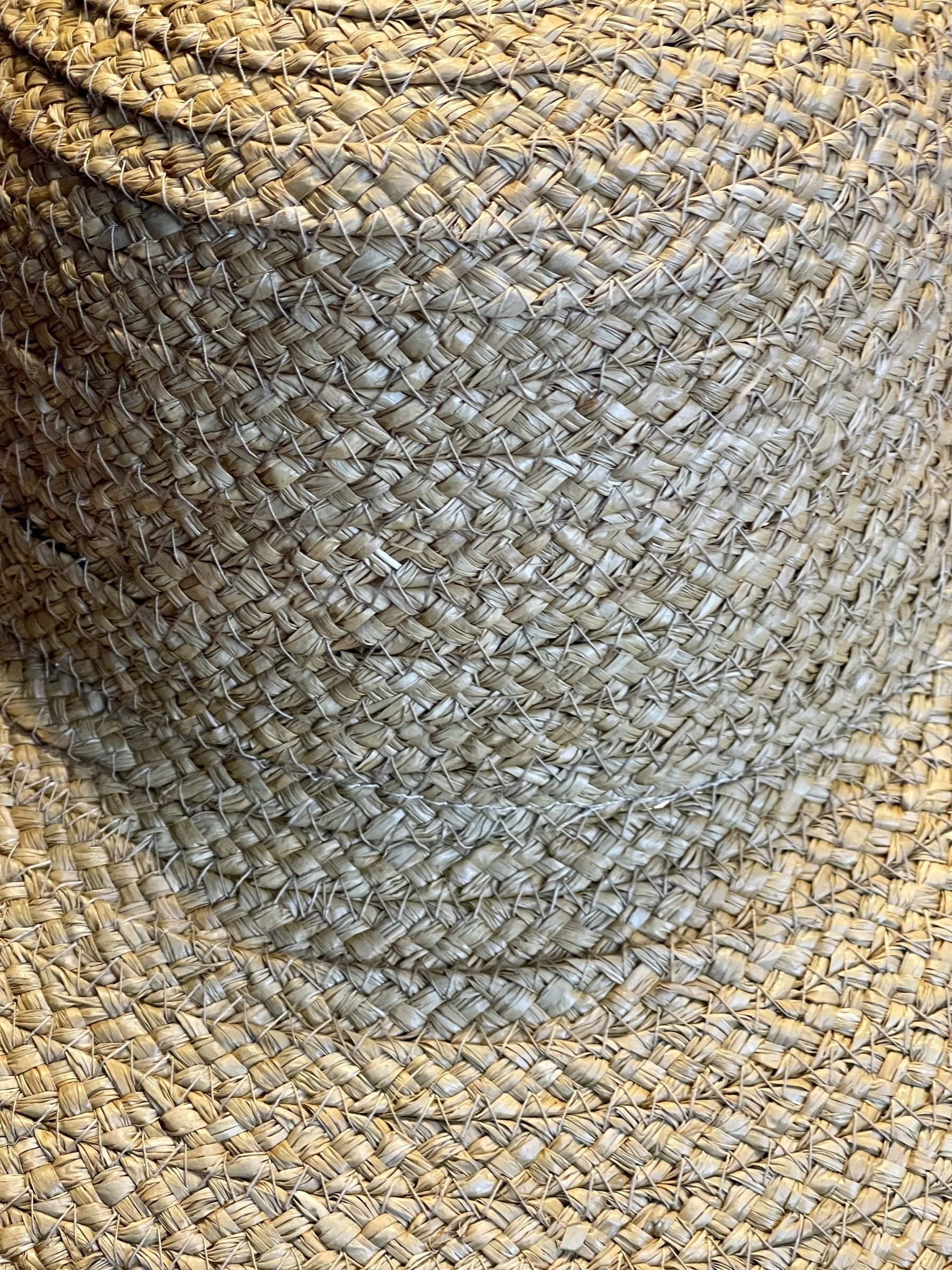 Closeup of crown and brim of a straw hat.