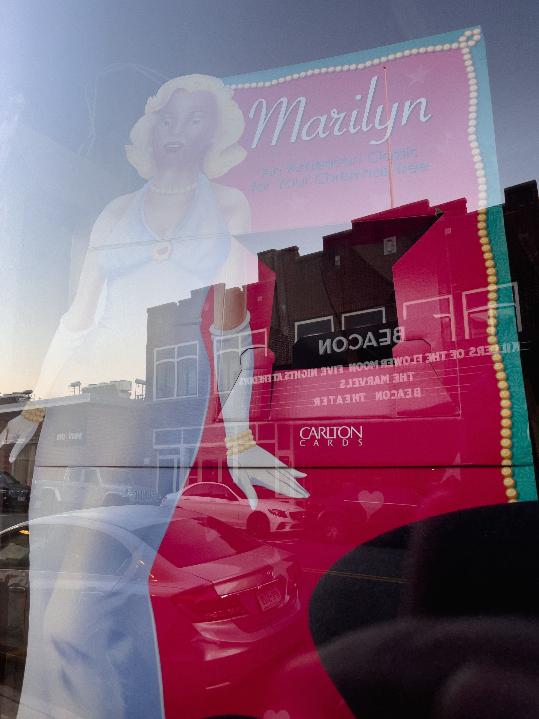 Vintage Marilyn movie poster in shop window, reflection of movie theater across the street overlaid.