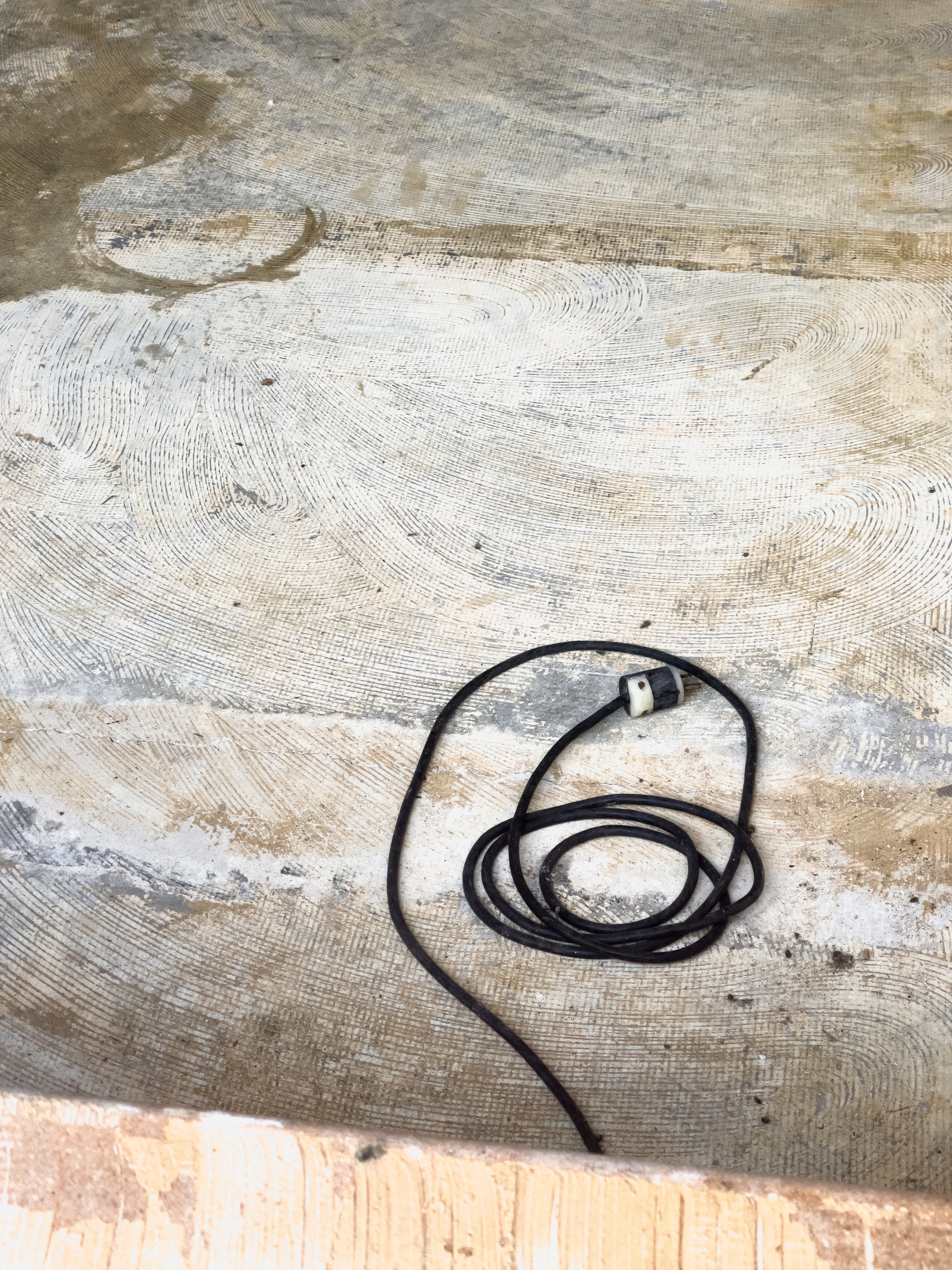 Concrete floor with coiled power cord.