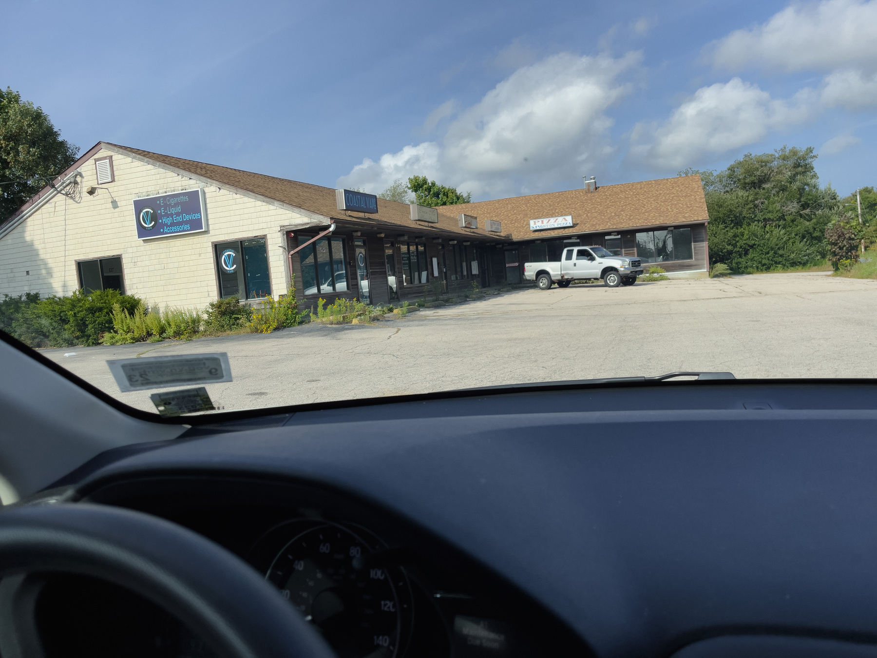 Strip mall buildings throughout car windshield.