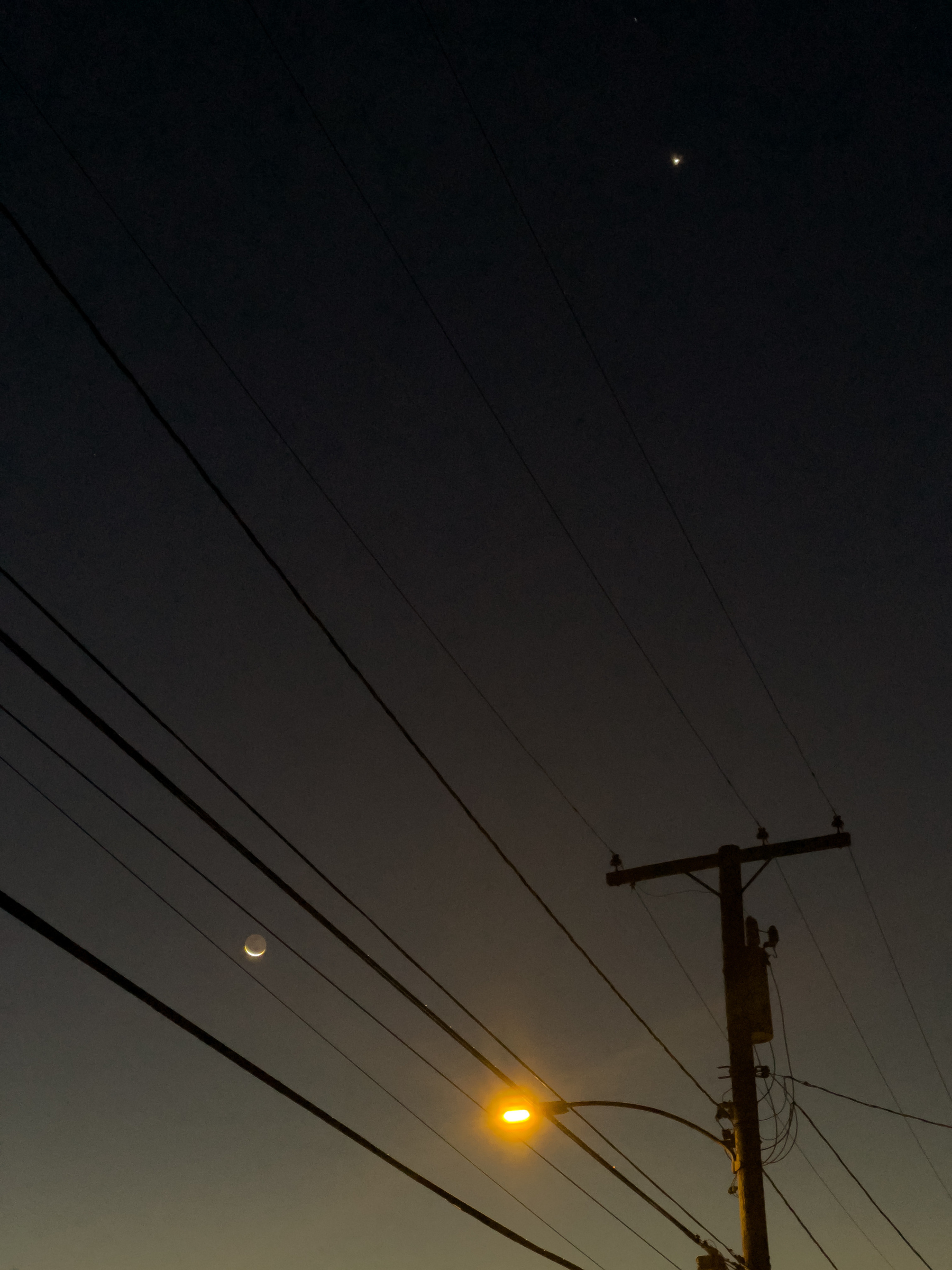 Venus and the Moon with silhouetted utility pole, wires and street light.