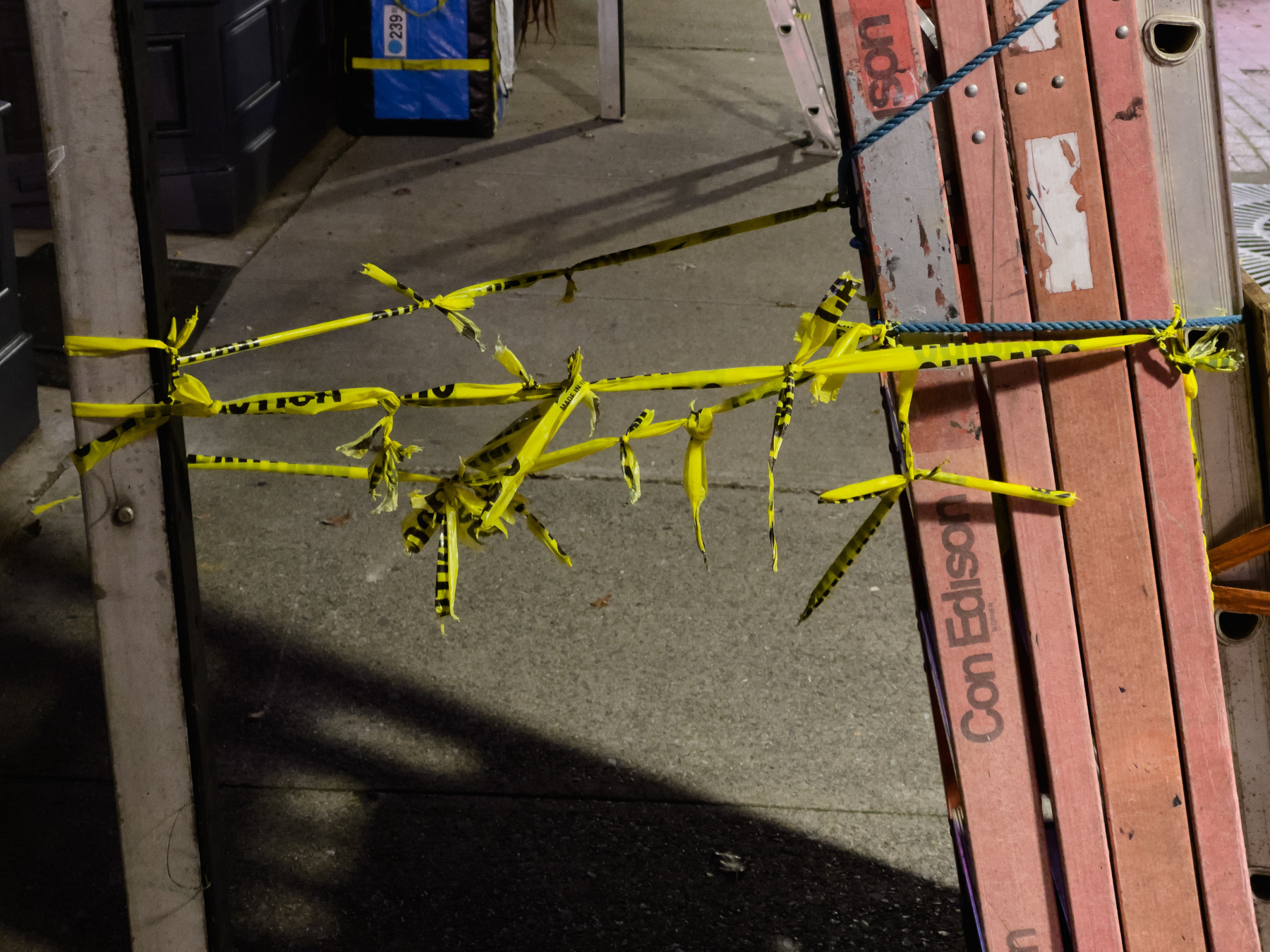 Spiked yellow caution tape stretched between scaffolding assembly.