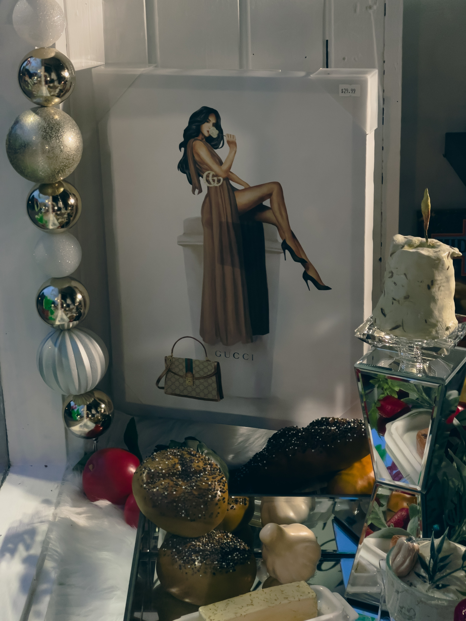 Photograph of women on a pedestal and festive objects in a shop window.