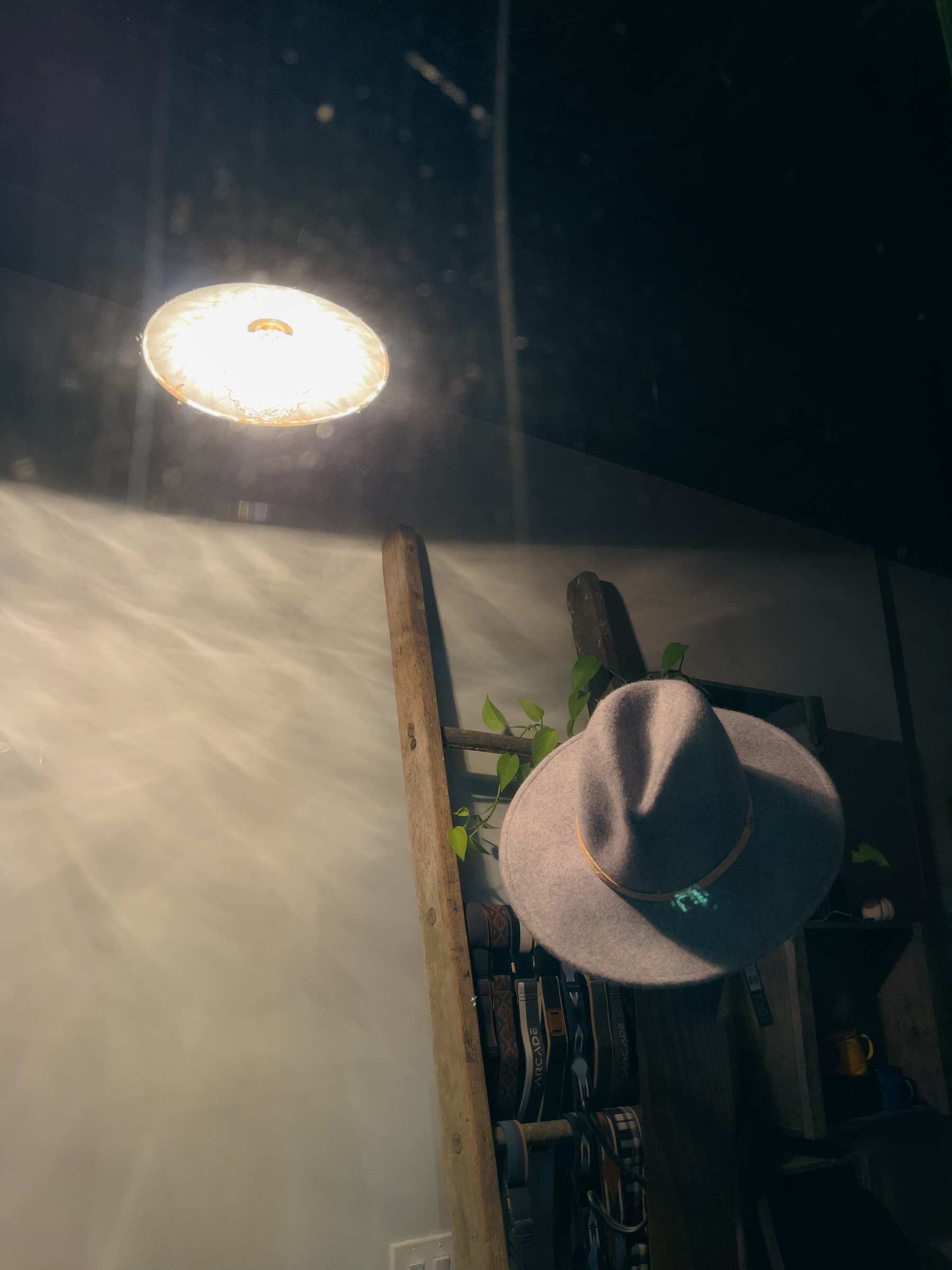 Felt hat and lamp in a shop window, lamp illuminating hat.