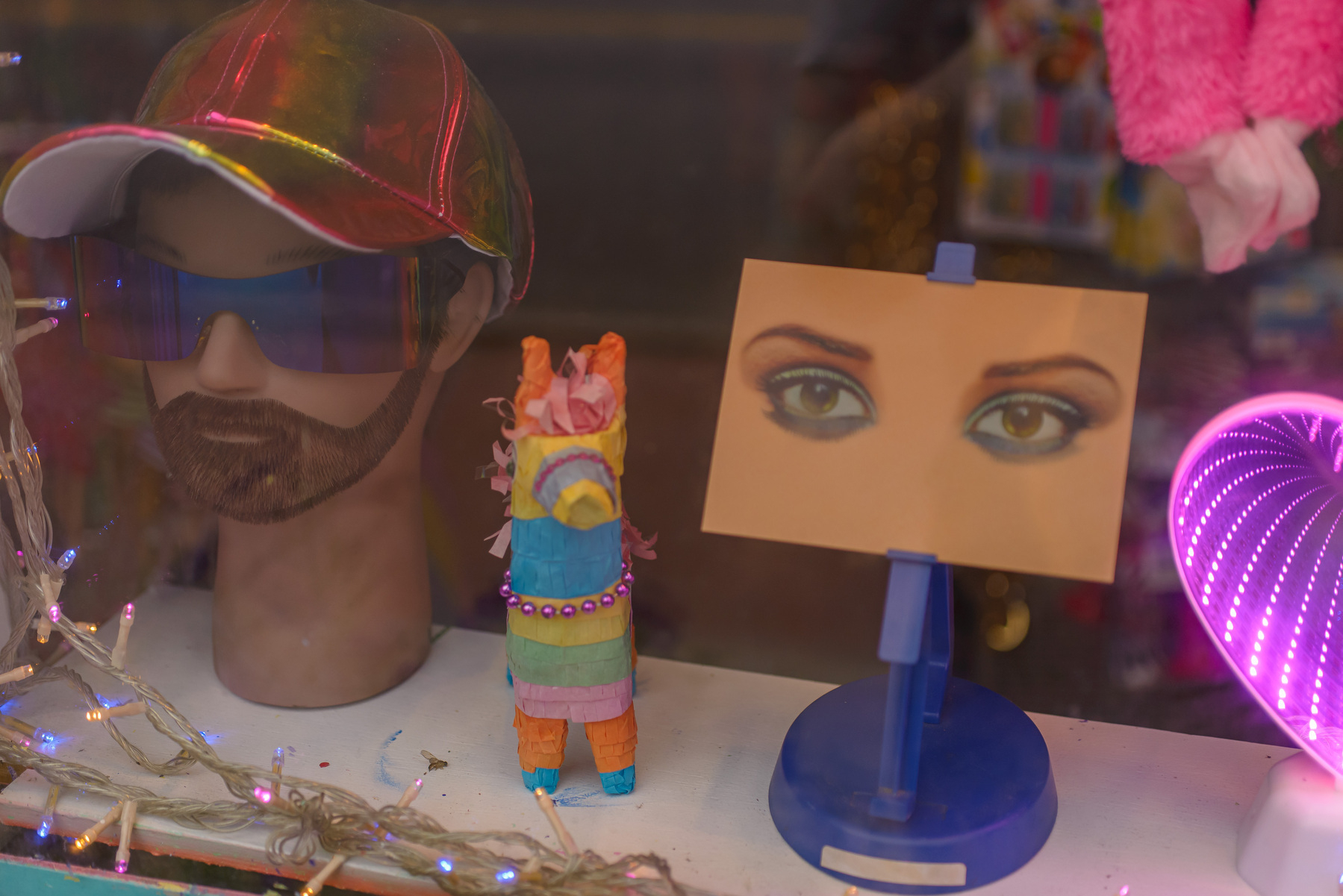 display in shop window with women’s eyes looking out from a rectangular card
