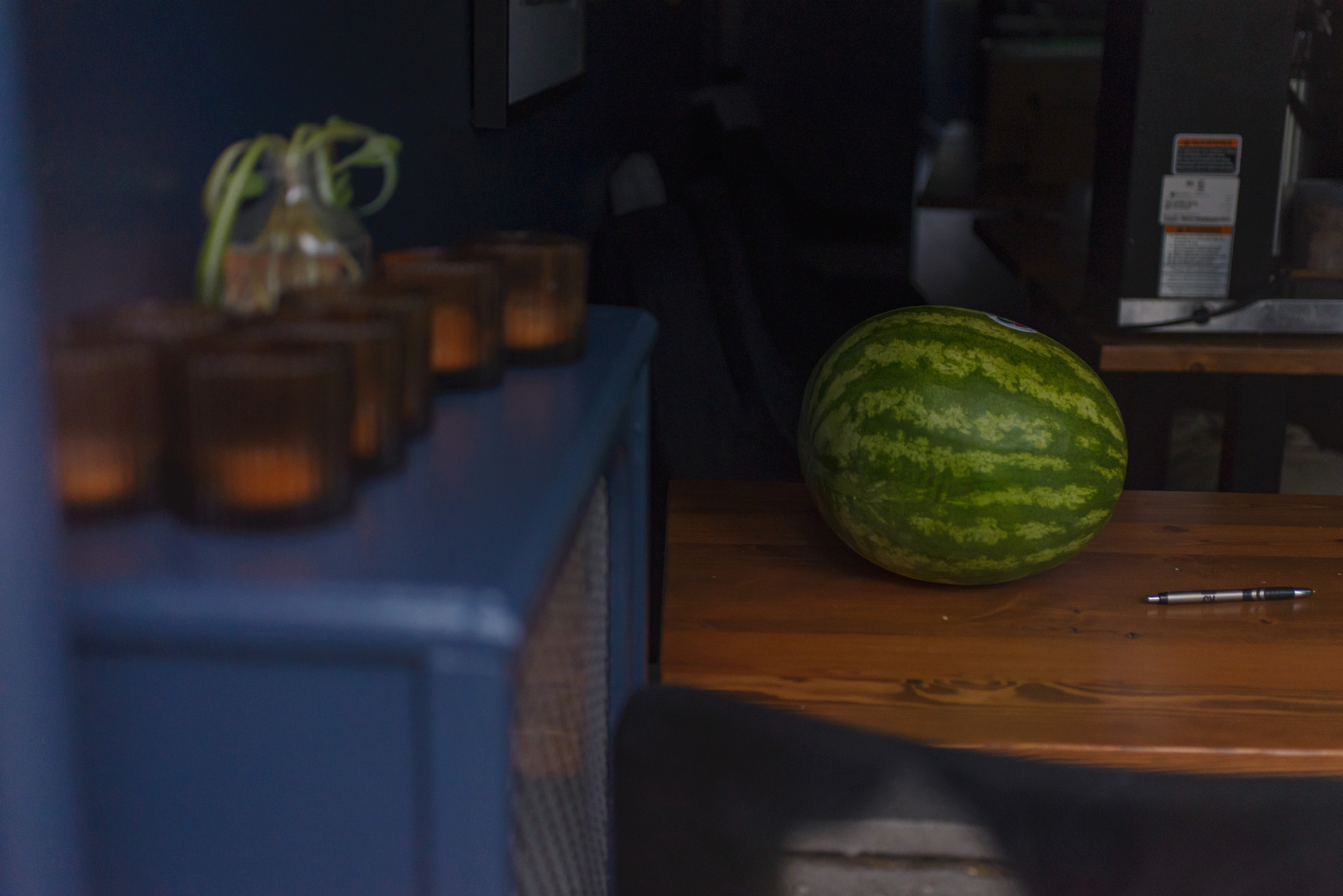 watermelon sitting on table in a restaurant various furnishings and accessories arrayed around the edges of the frame