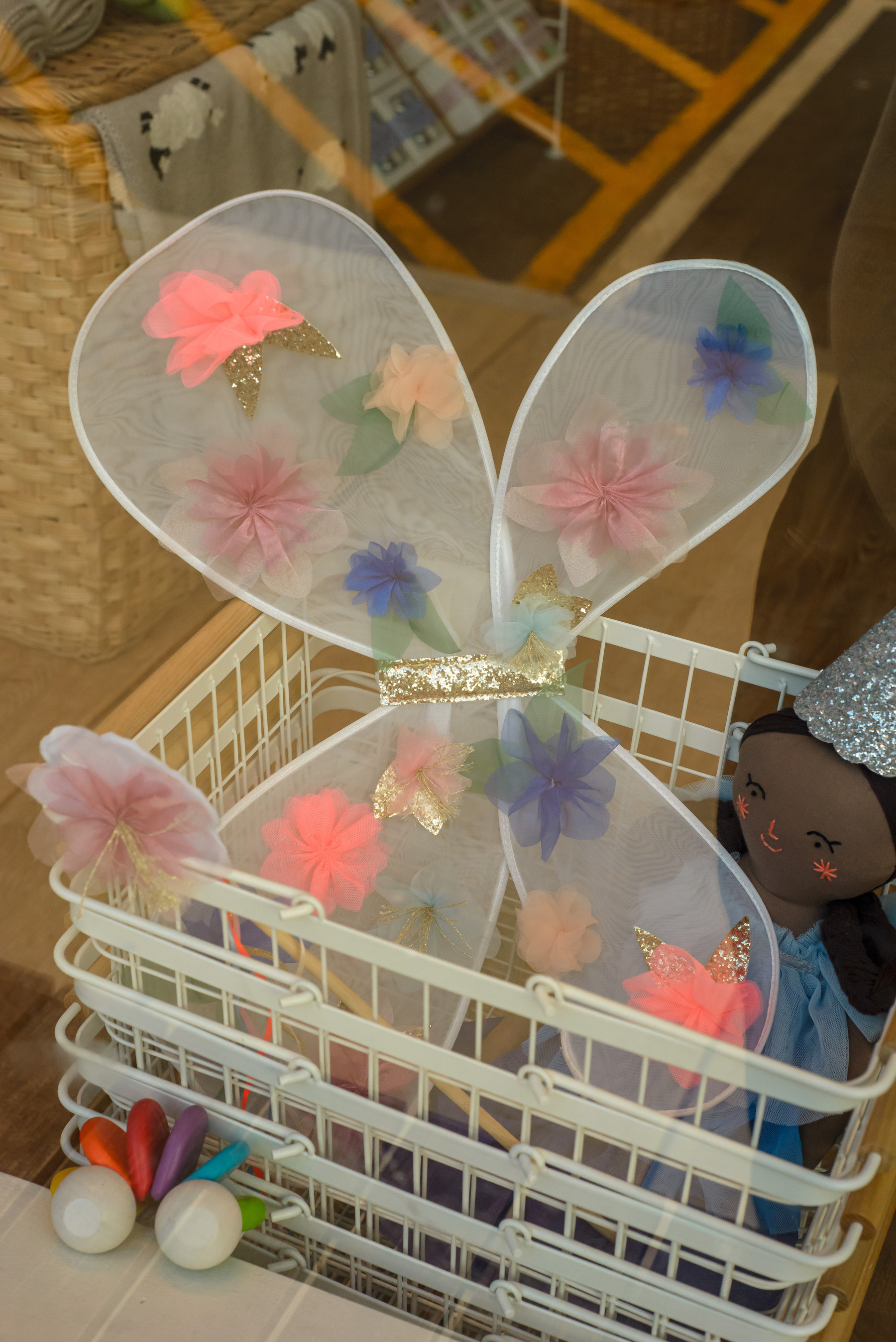 Child’s fairy wings in a shopping basket in a shop.
